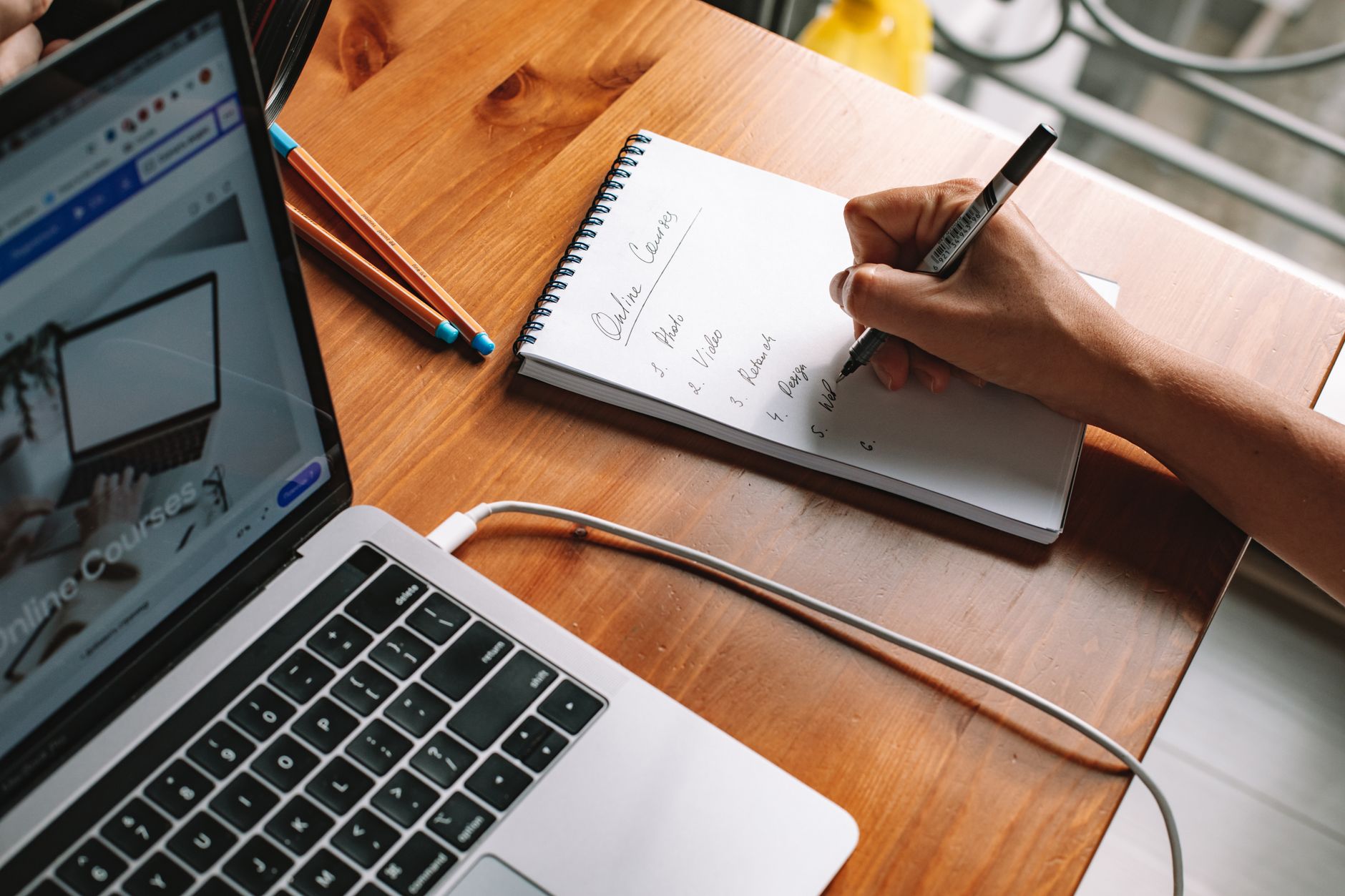 A course creator planning their website content at a desk