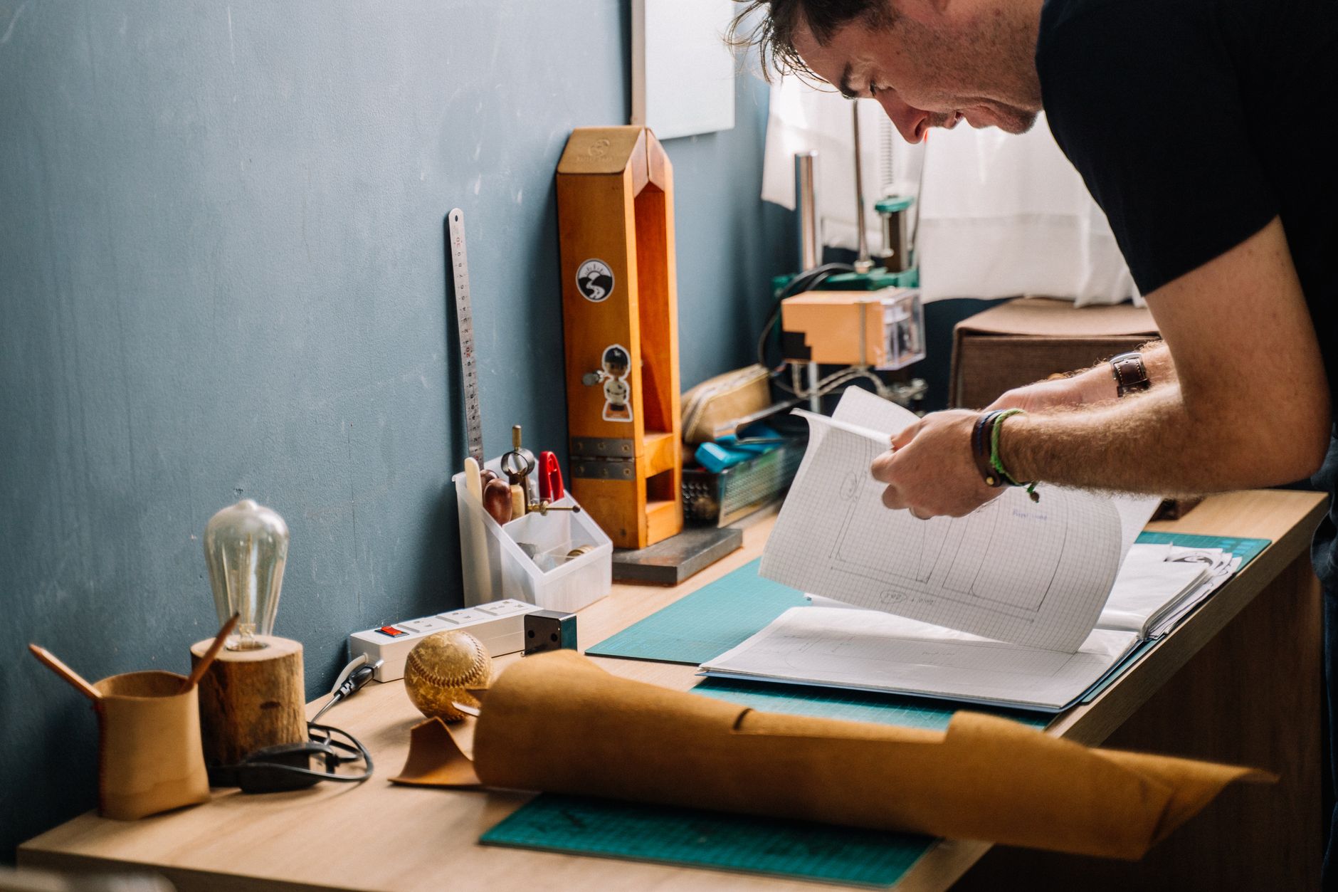 A designer reviewing hand-drawn logo sketches at a studio desk