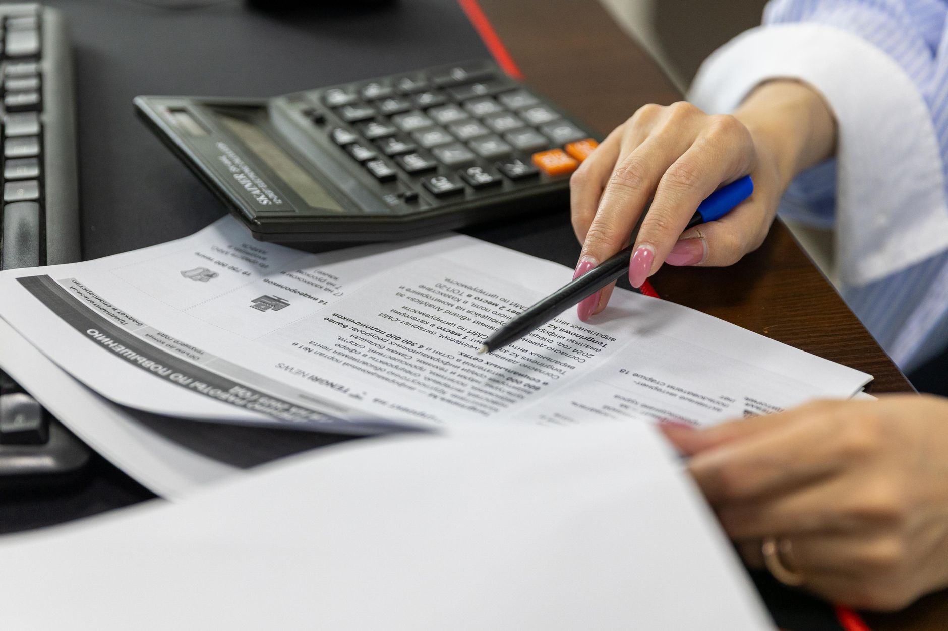 A small business owner working out a marketing budget at a desk