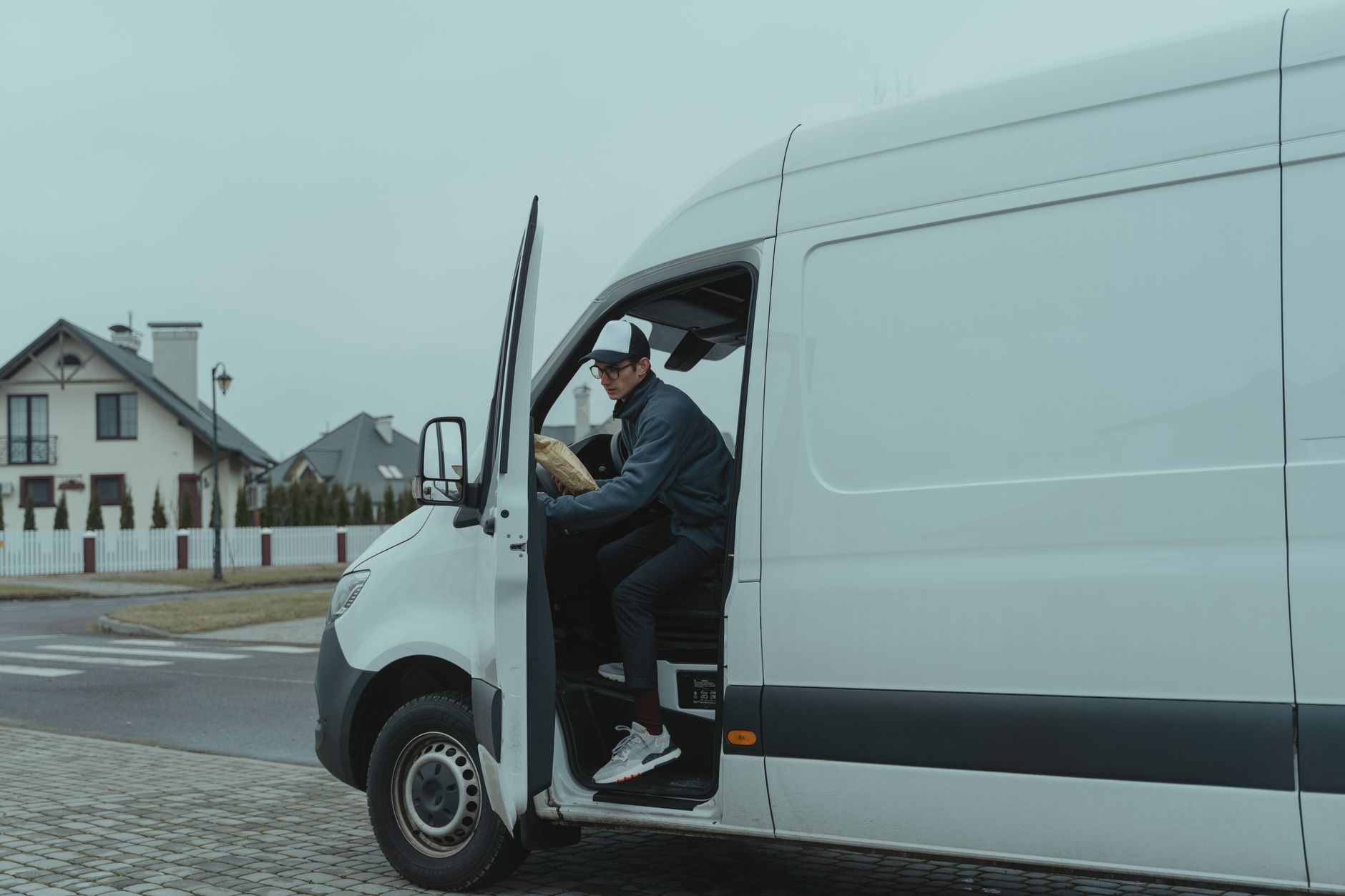 A tradesman checking a job enquiry on his phone beside his van