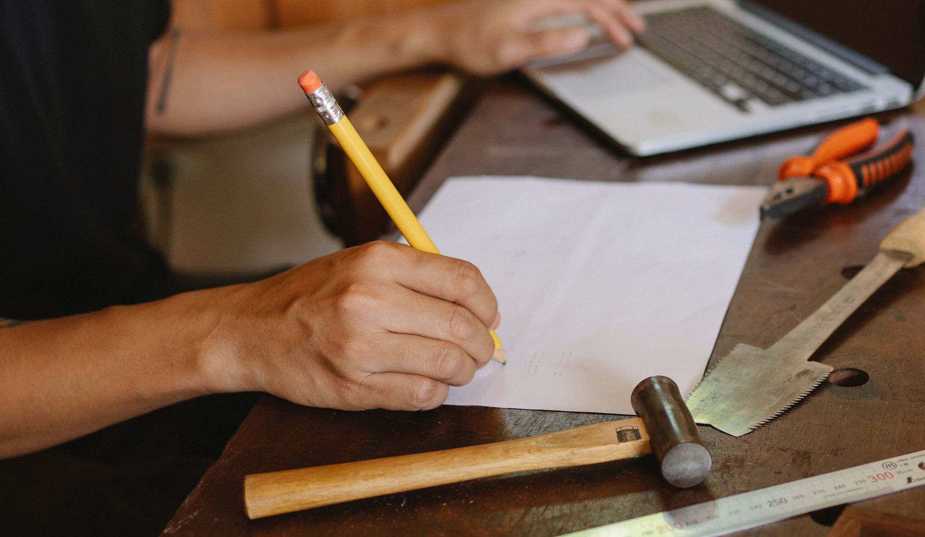 A jewellery maker writing down what makes her work distinctive