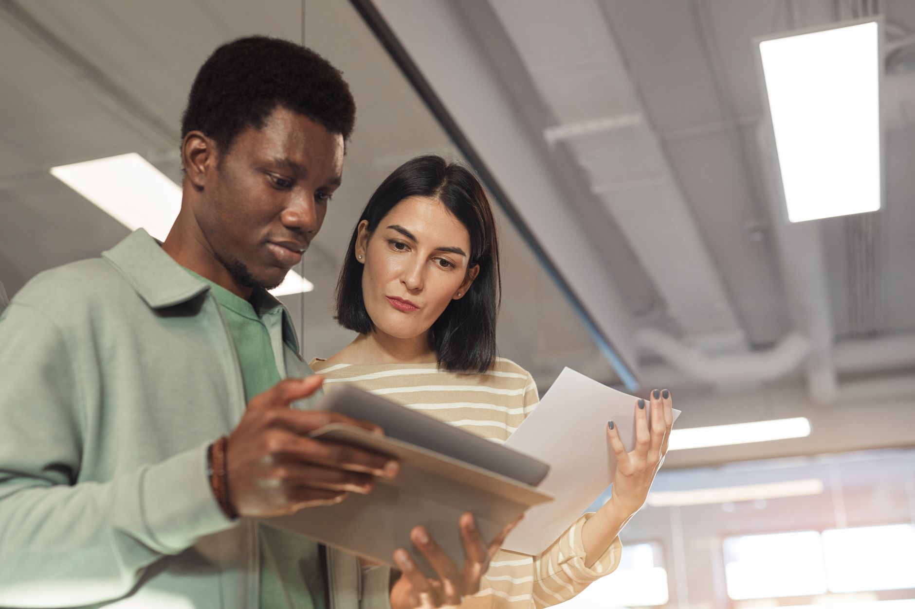 Two colleagues reviewing how a product listing appears across search and AI tools