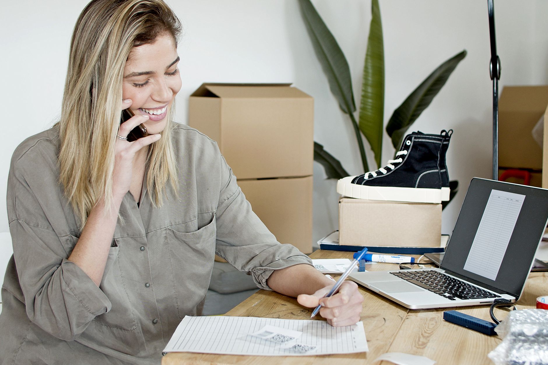 A shop owner answering a customer enquiry from her stockroom
