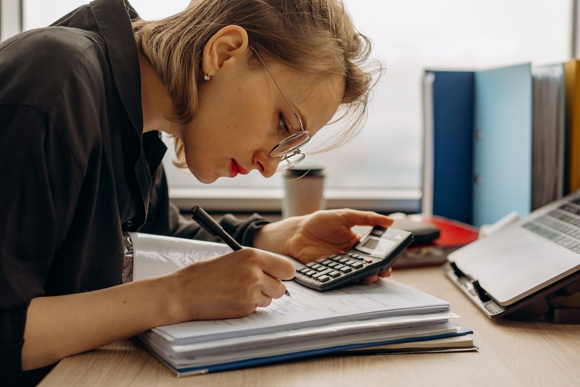 An accountant using AI tools alongside paperwork in daily practice