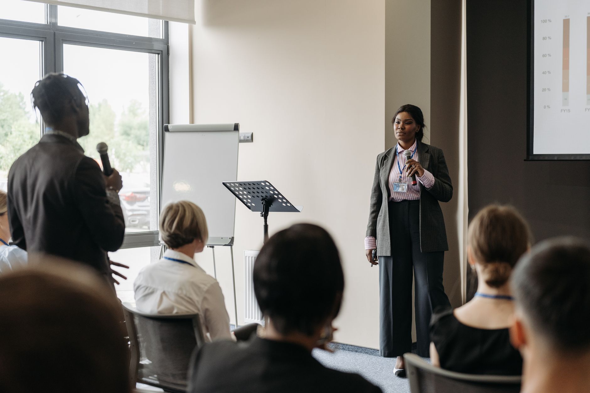 A woman giving a business talk to a small audience to build authority