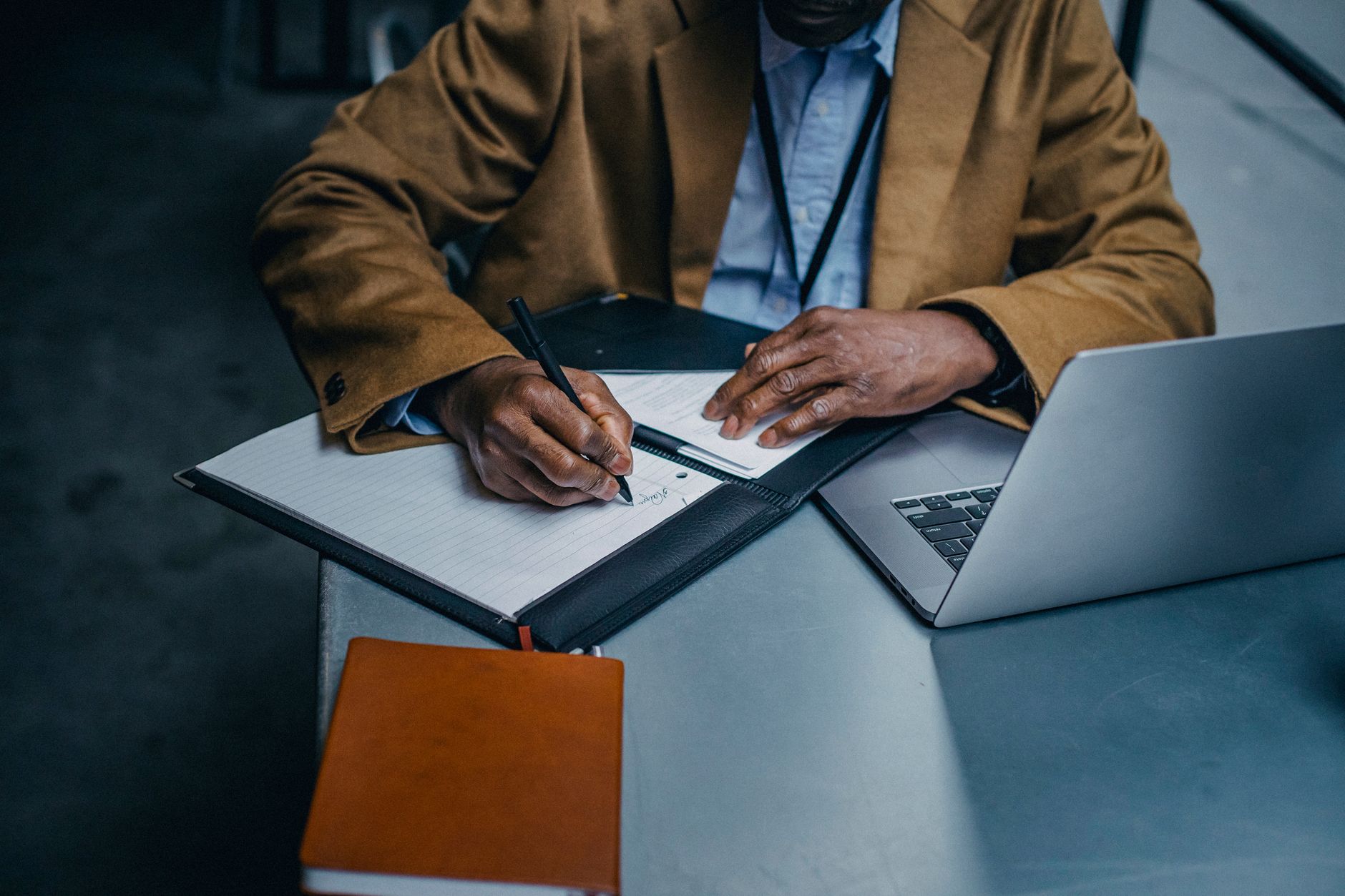 A business owner writing a shortlist of target clients in a notebook