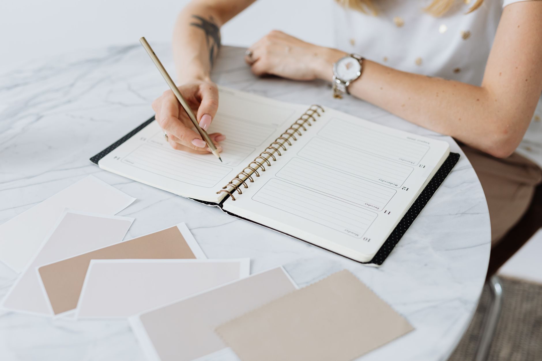 A business owner writing out a three month plan in a notebook