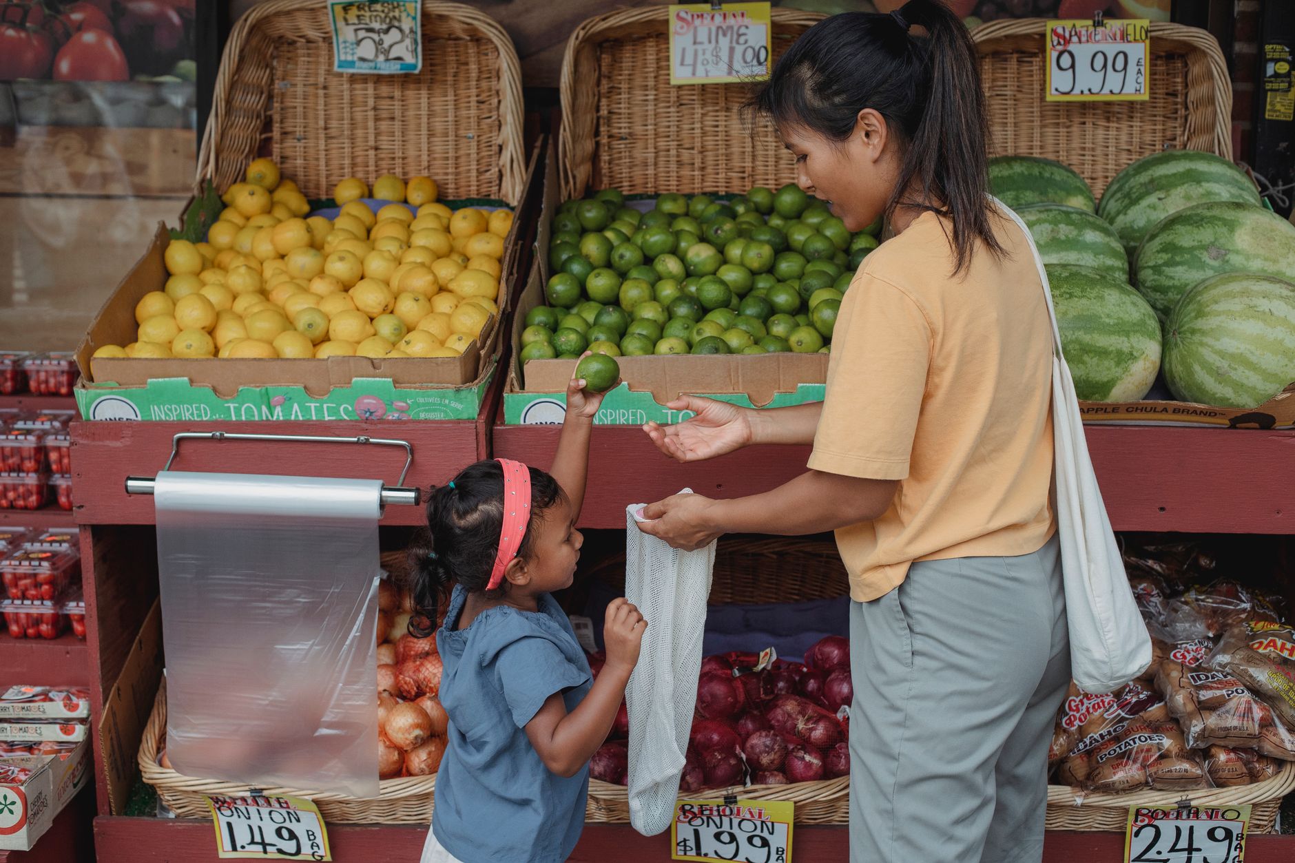 A parent helping their child choose a school bag in a local shop