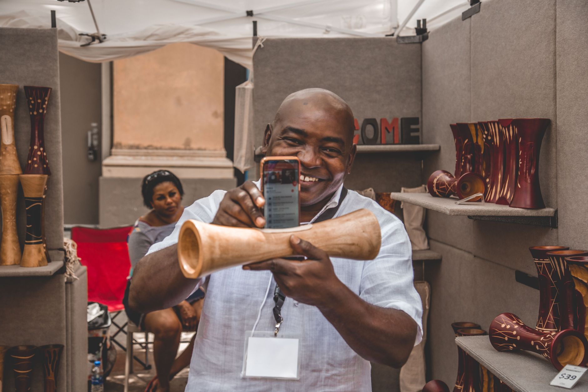 A customer watching a maker's process video at a market stall
