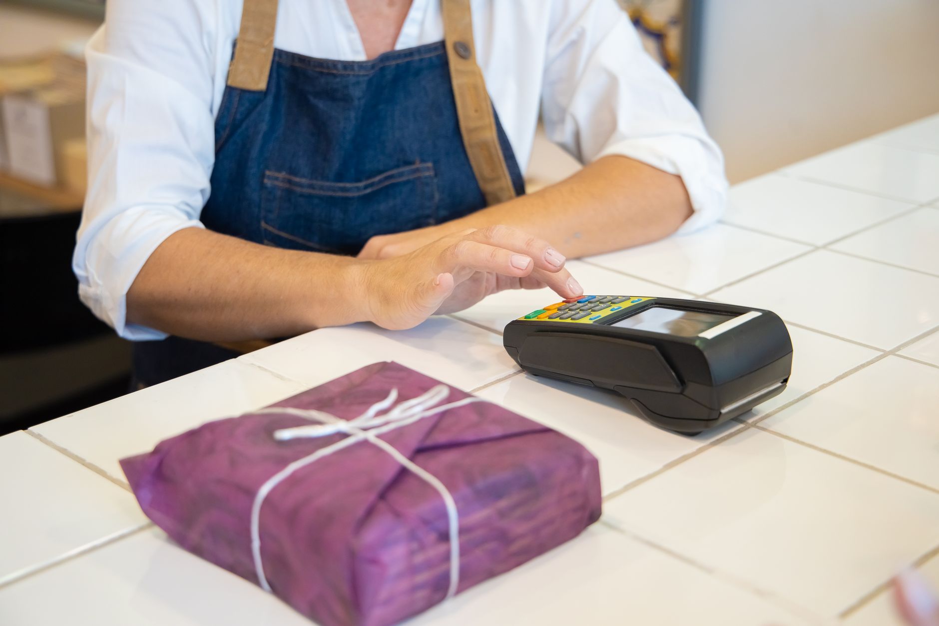 A shopkeeper rewarding a loyal customer with a small thank-you gift