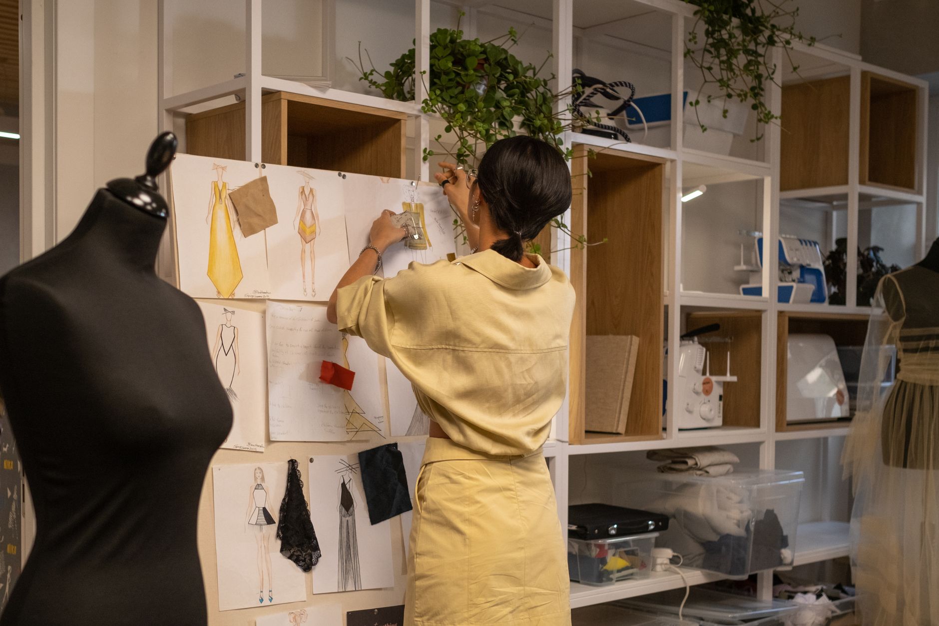 A designer arranging colour swatches and logo versions on a studio wall