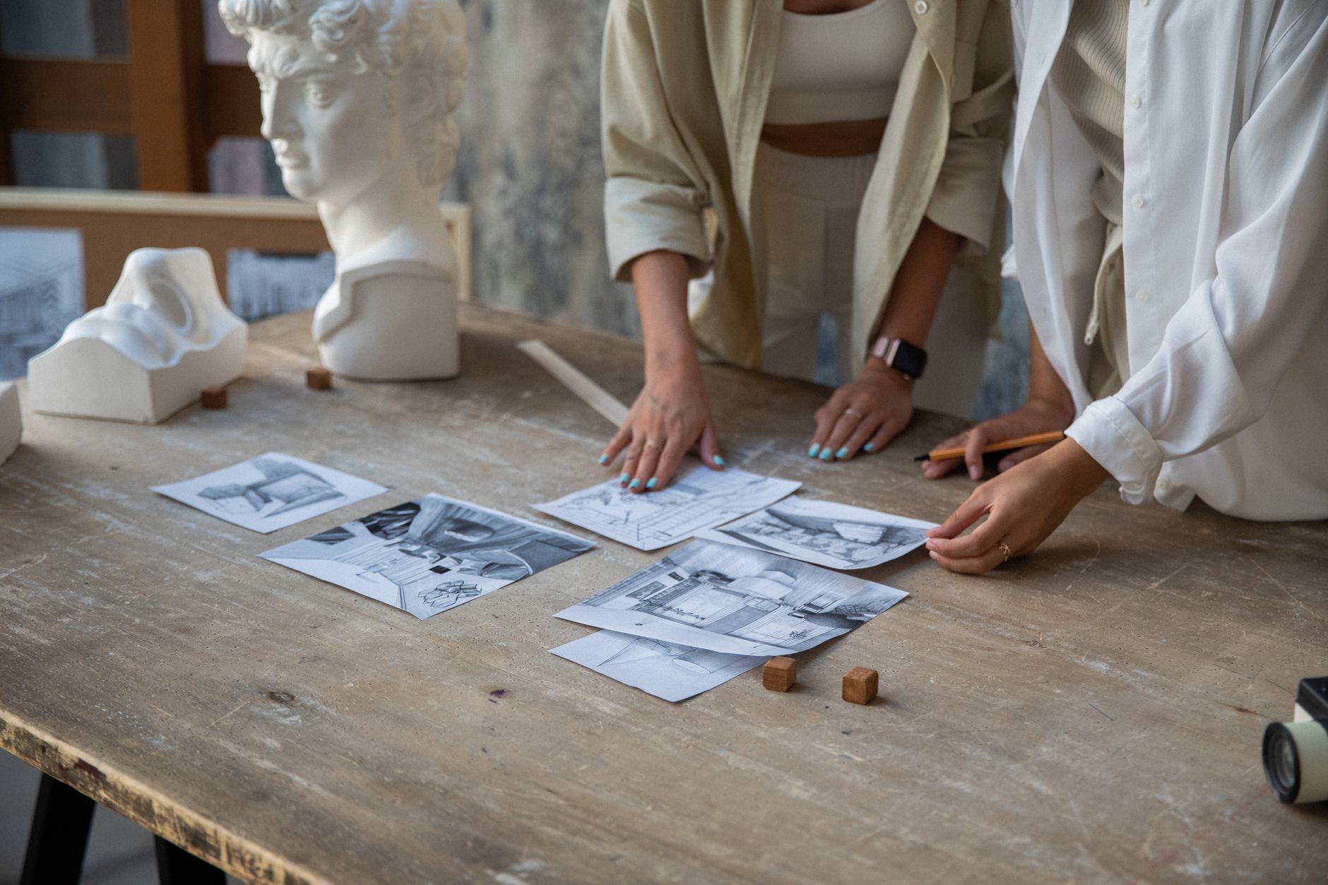 A designer and business owner discussing brand artwork at a desk