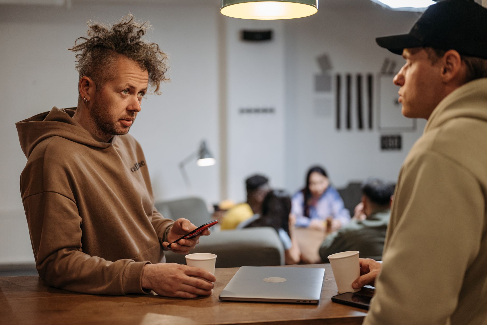 Two colleagues talking through their brand over coffee at a cafe table