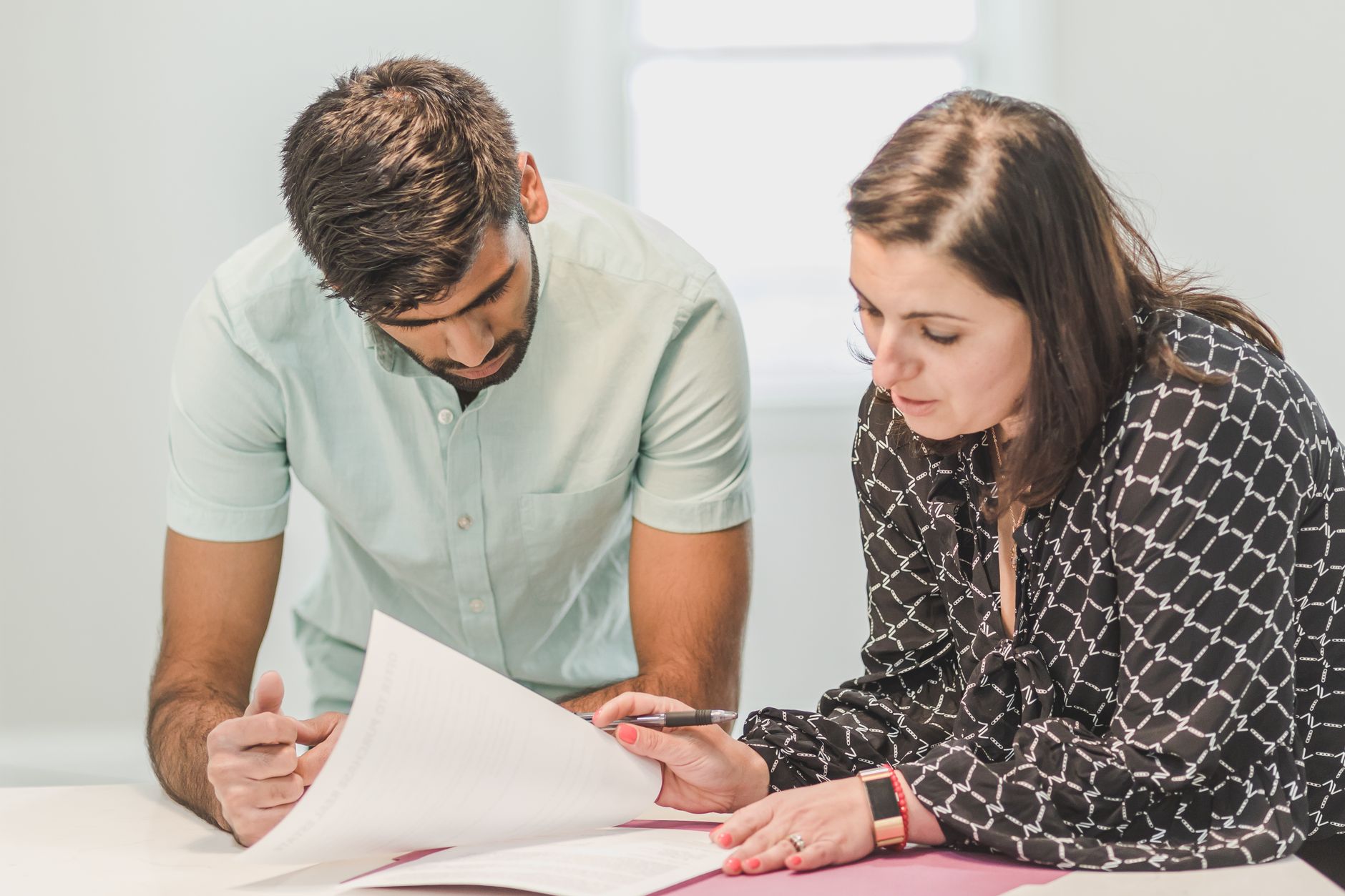 Two consultants comparing draft proposals before sending them