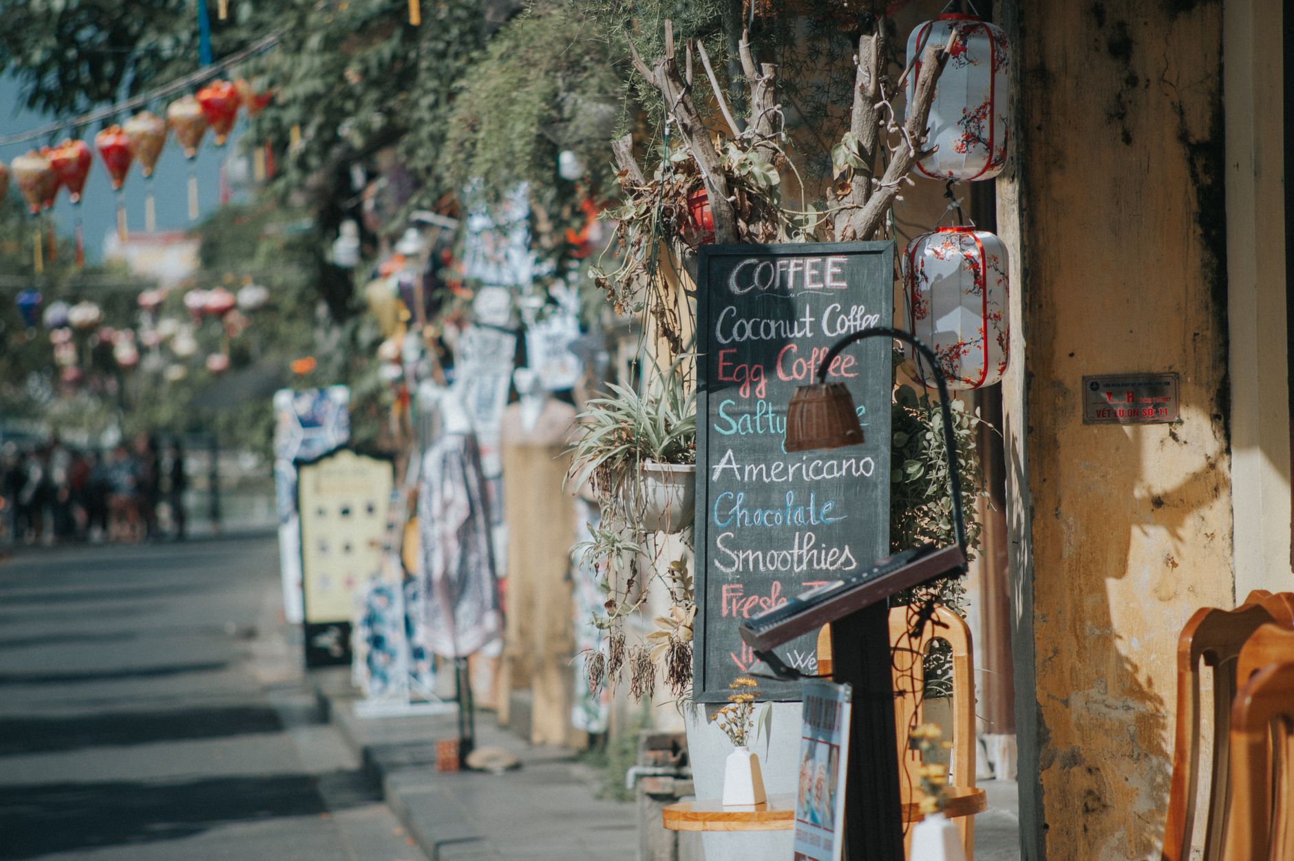 A cafe owner updating a festive sign outside their business