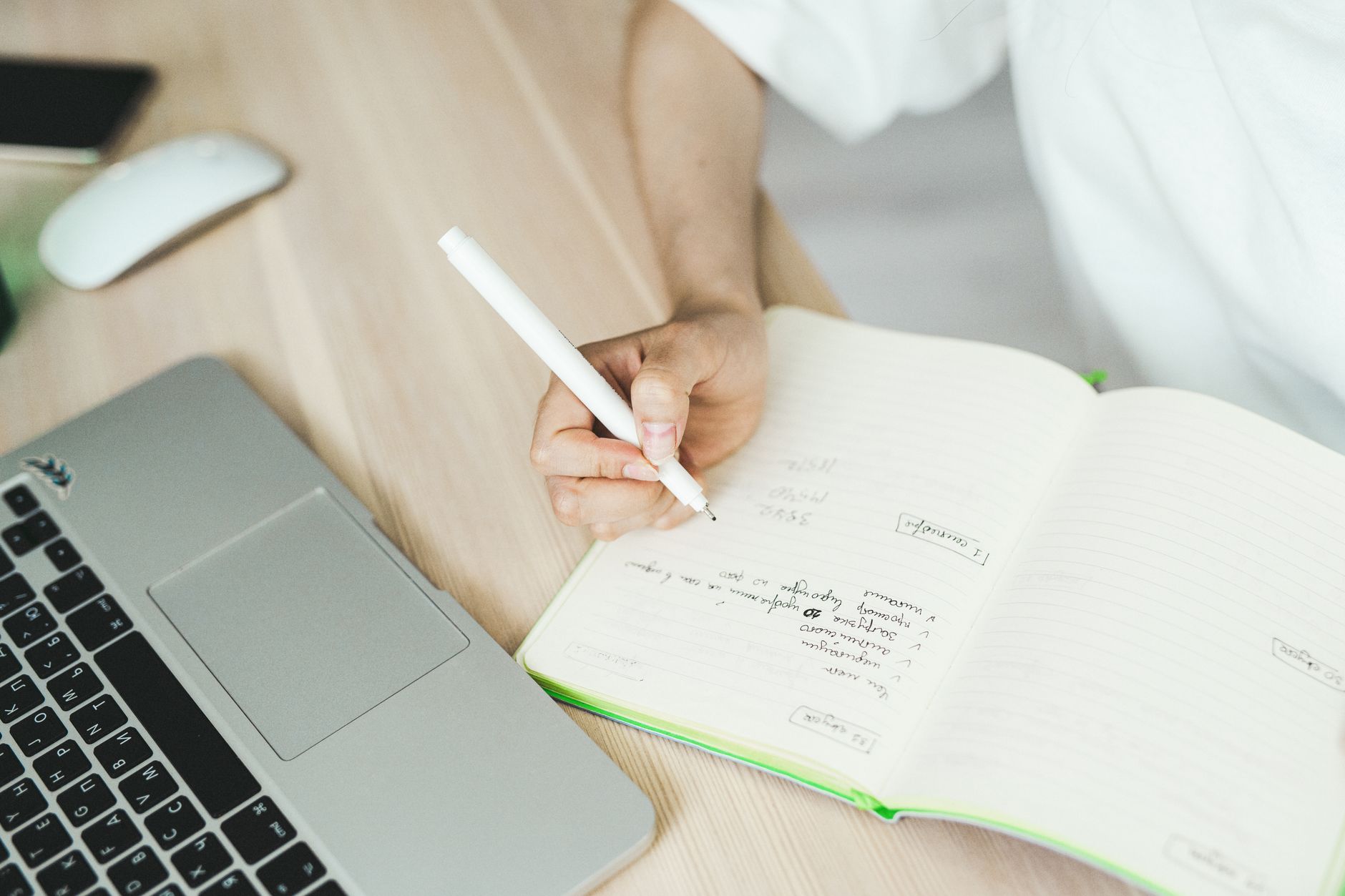 A small business owner planning content ideas in a notebook at a desk