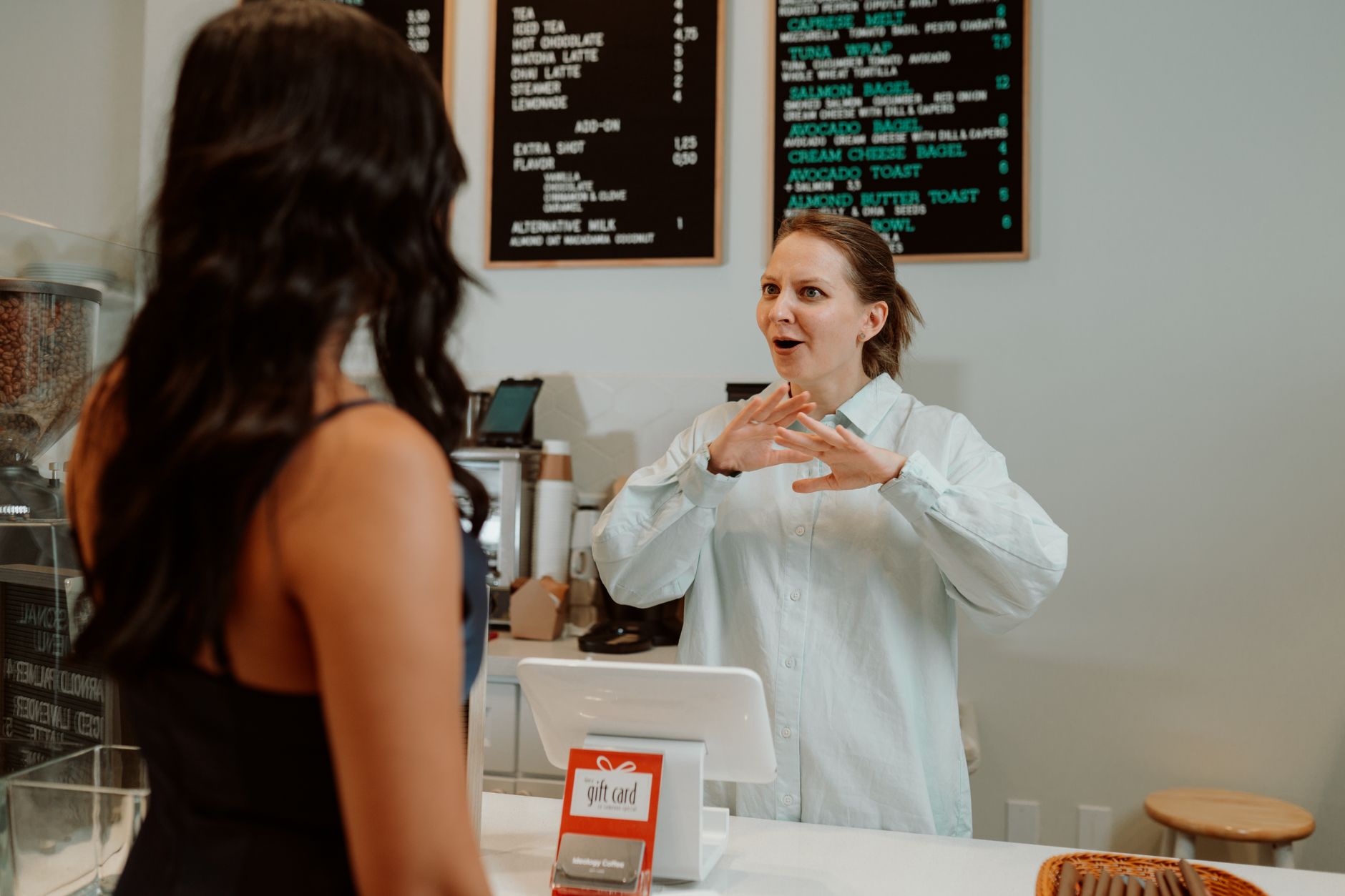 Two cafe owners setting up a shared loyalty scheme at the counter