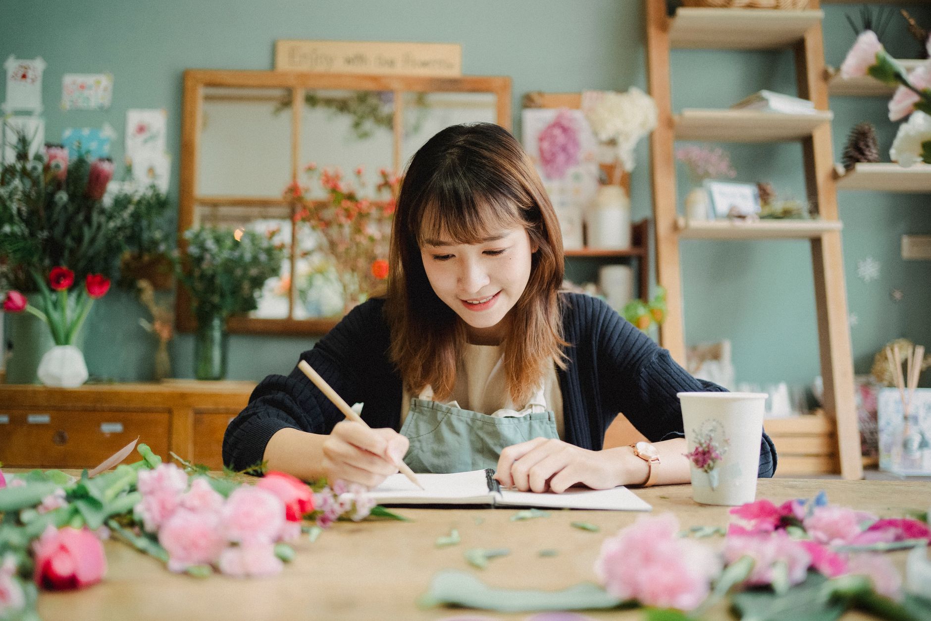 A shop owner noting down how a customer heard about the business