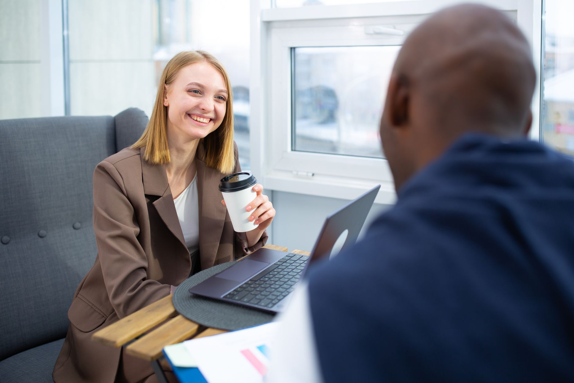Two colleagues discussing a new customer enquiry over coffee