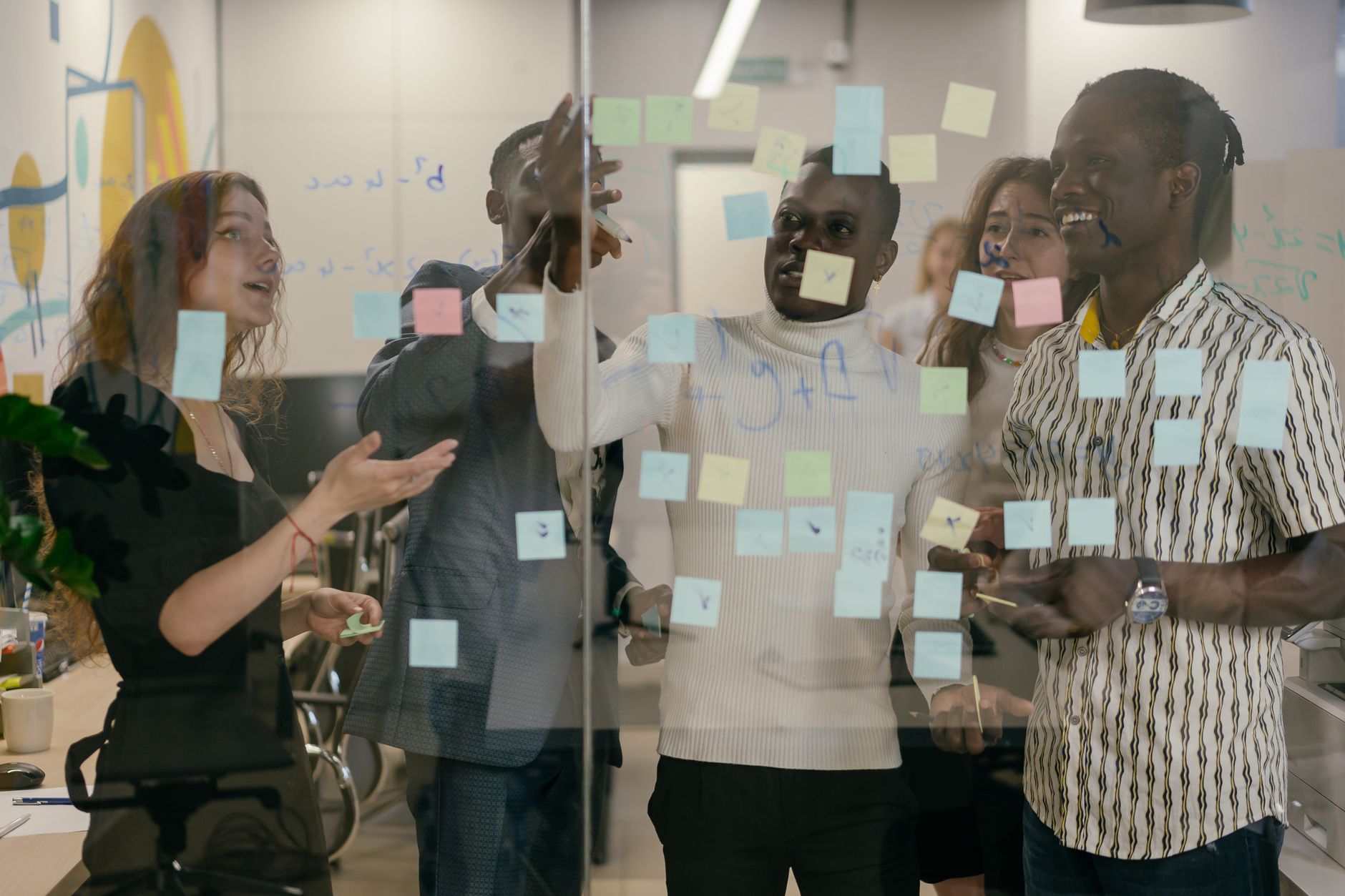 A small team building a step by step acquisition process with sticky notes