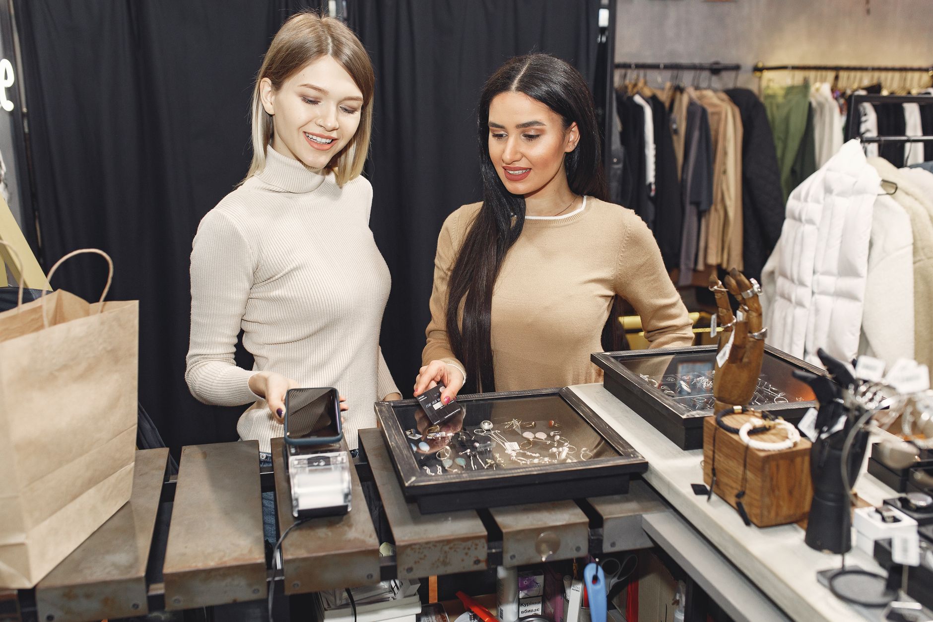 A customer holding a loyalty card while paying at a till
