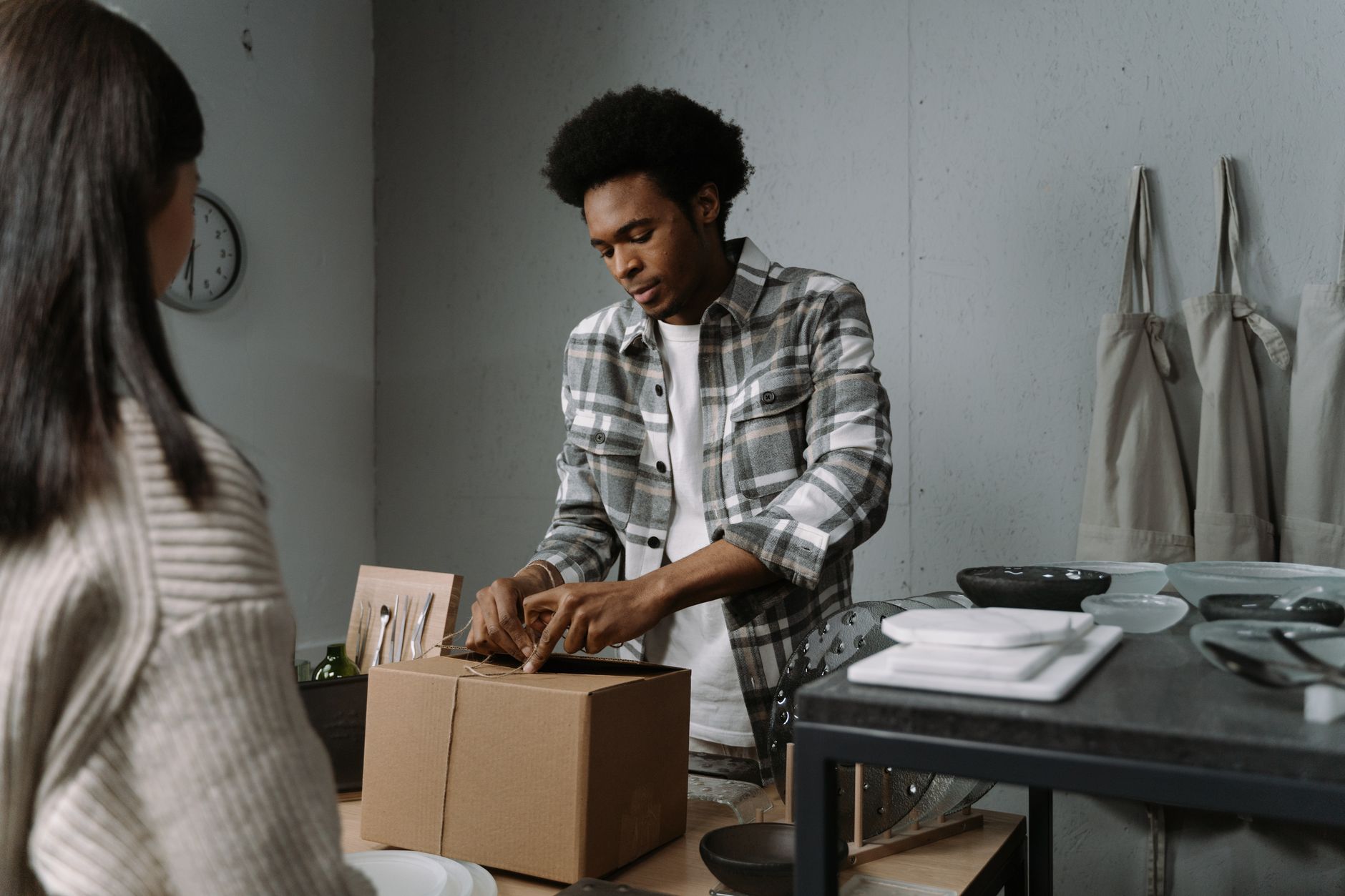 A seller preparing products for dispatch in their own small workspace