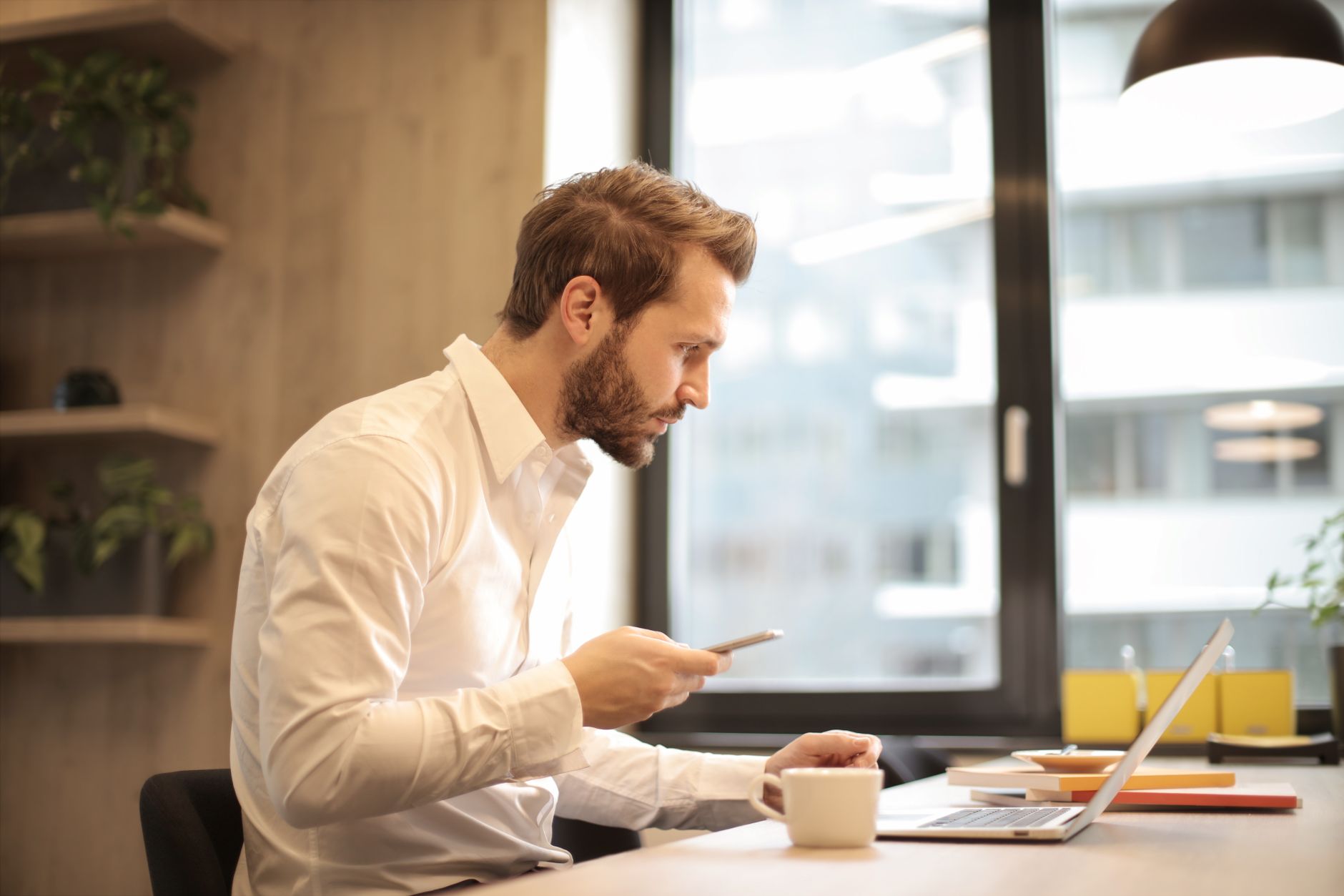 A focused small business owner reviews an email platform dashboard on a laptop, checking how recent sends performed.