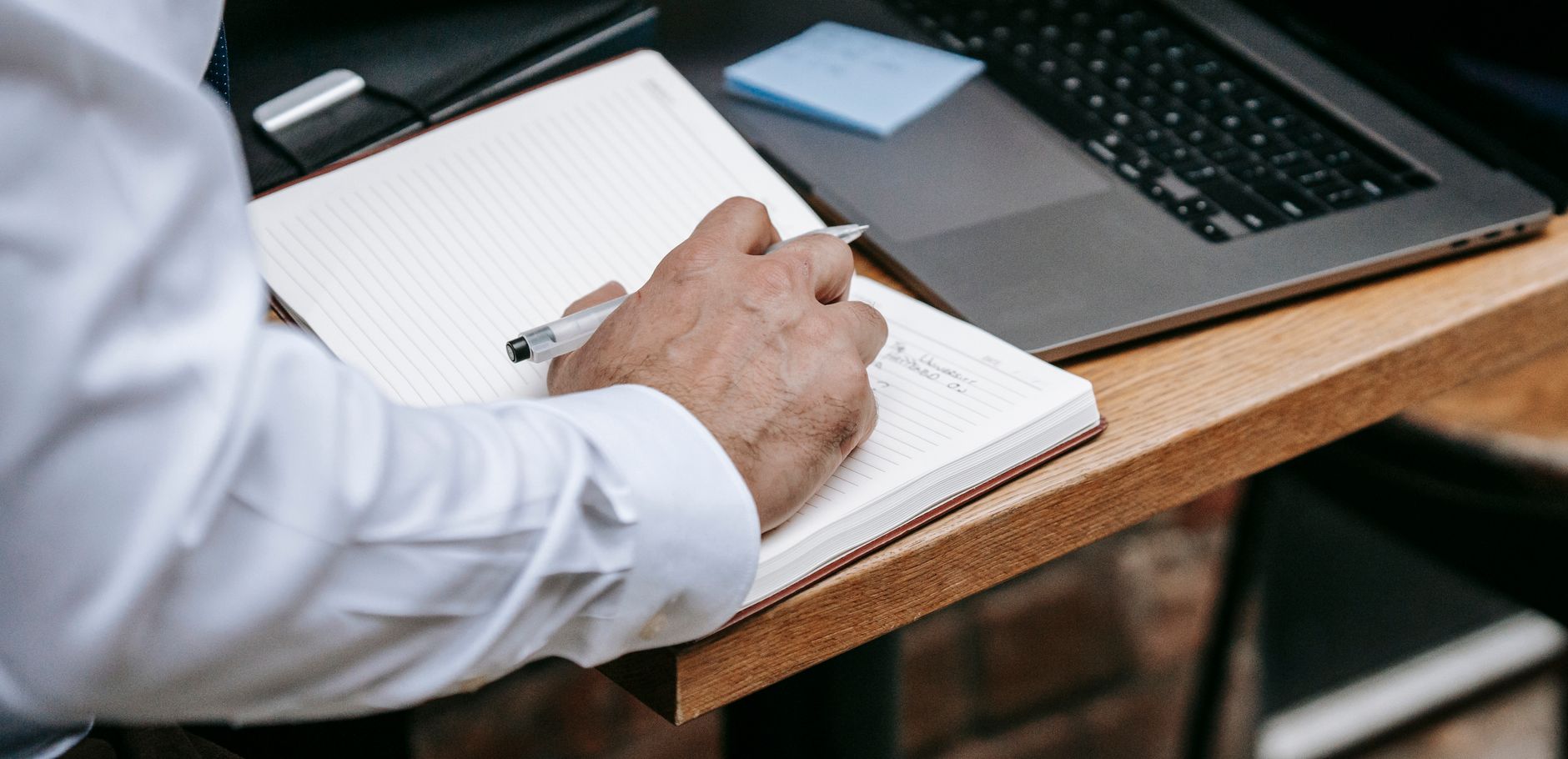 A business owner drafting subject line ideas by hand before typing