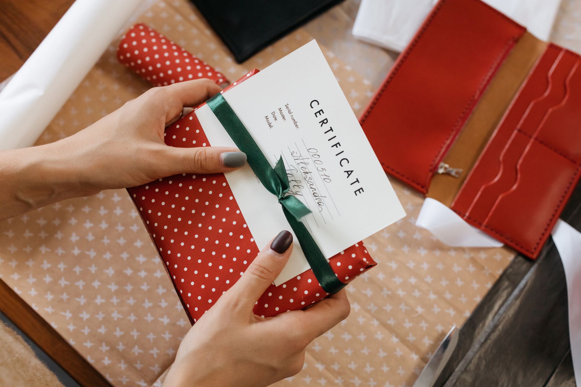 A person giving a wrapped gift voucher to a friend