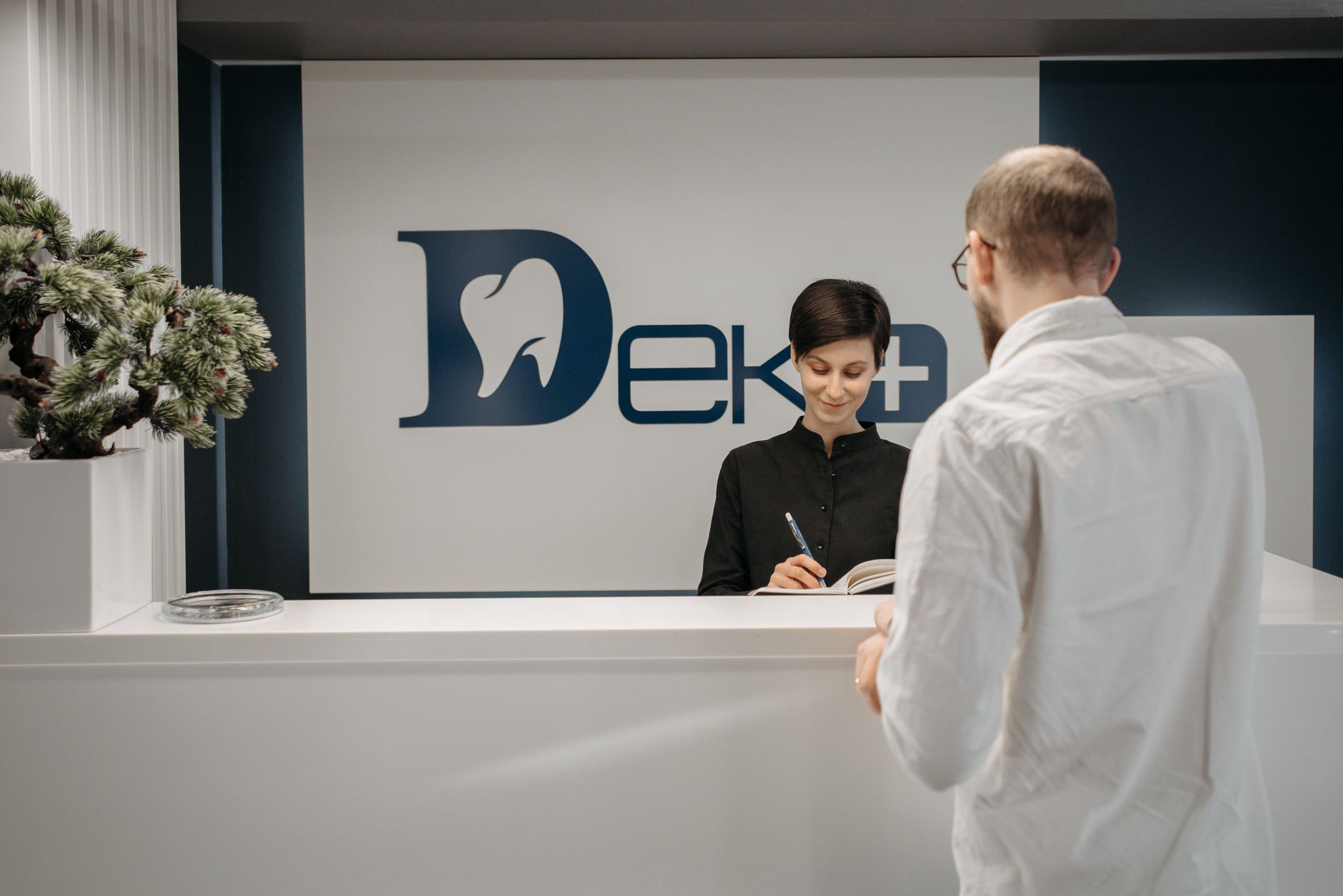 A dentist writing an update to share with patients at the front desk