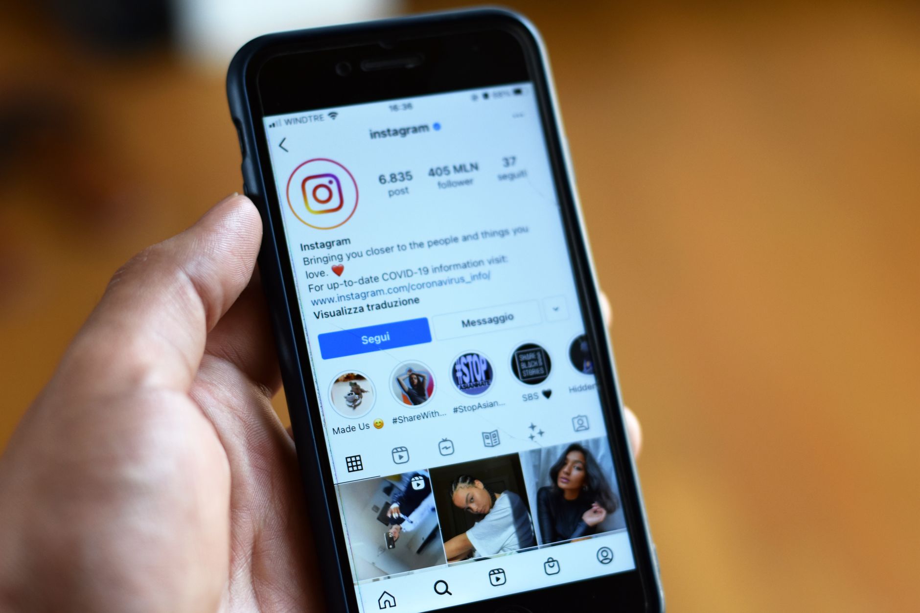 A customer types a local search into Instagram on their phone, browsing the explore results for a nearby business to follow.
