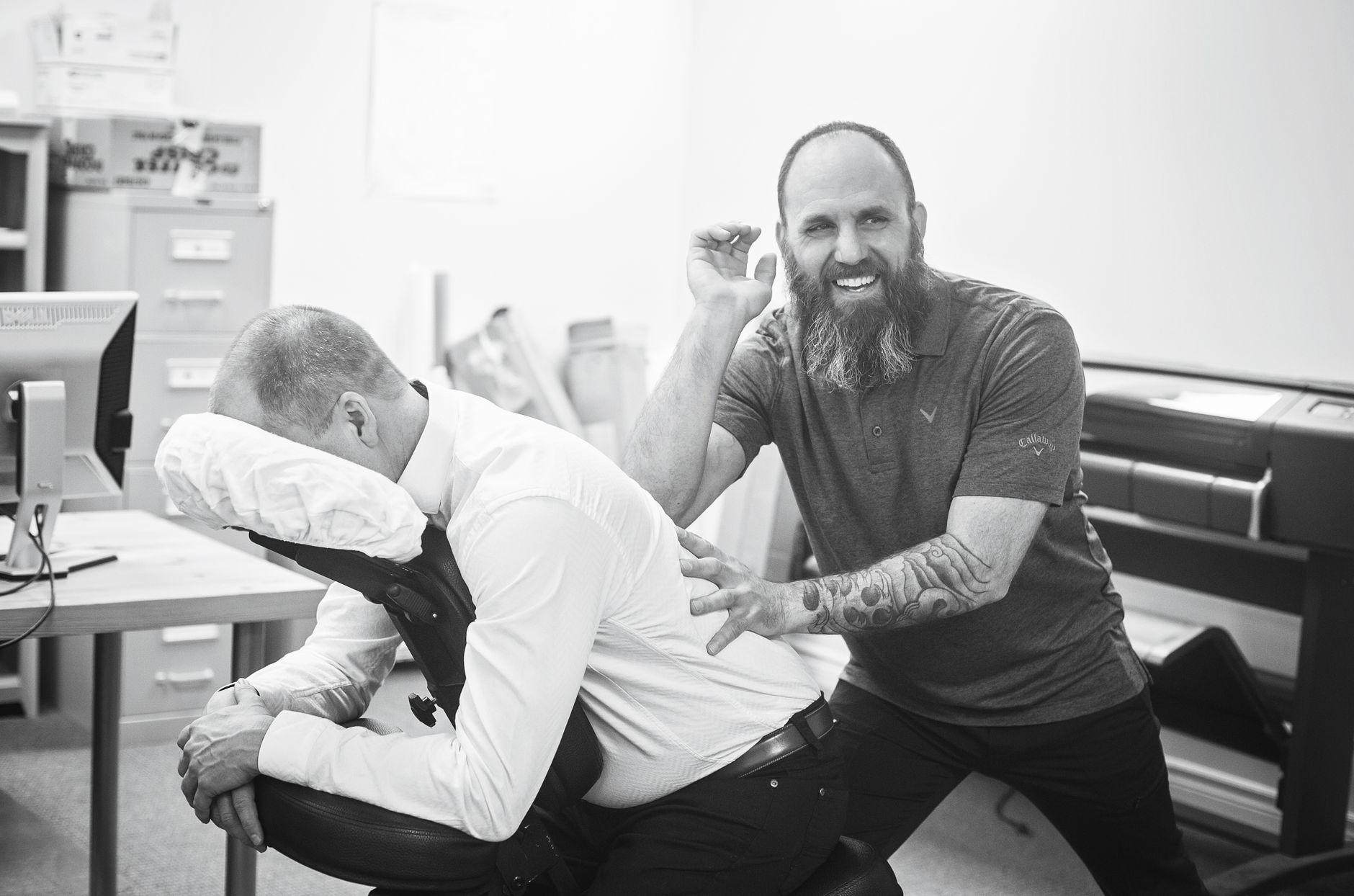 A therapist delivering an on-site chair massage in a company office