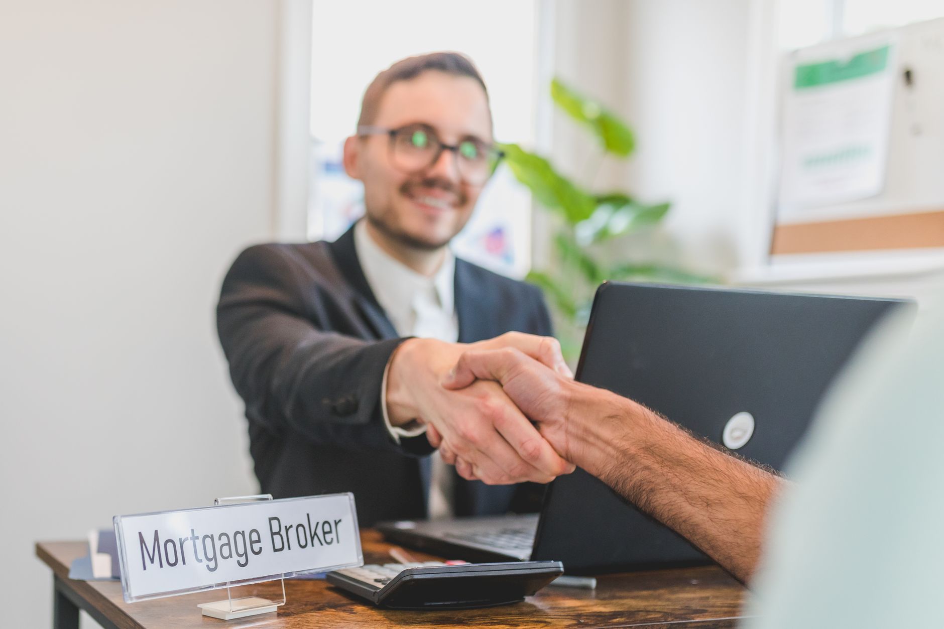 Tradesperson shaking hands with a happy customer on a doorstep at the end of a completed job