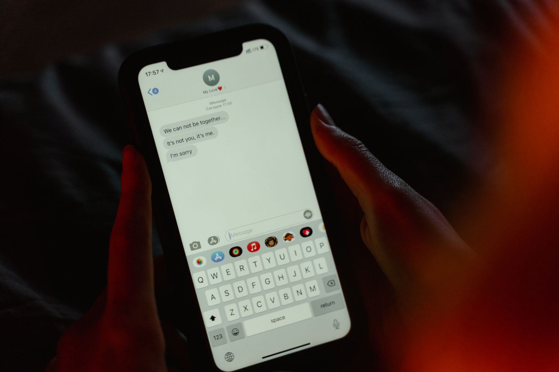 Close-up of a hand sending a text message on a smartphone, illustrating a review-request message being sent