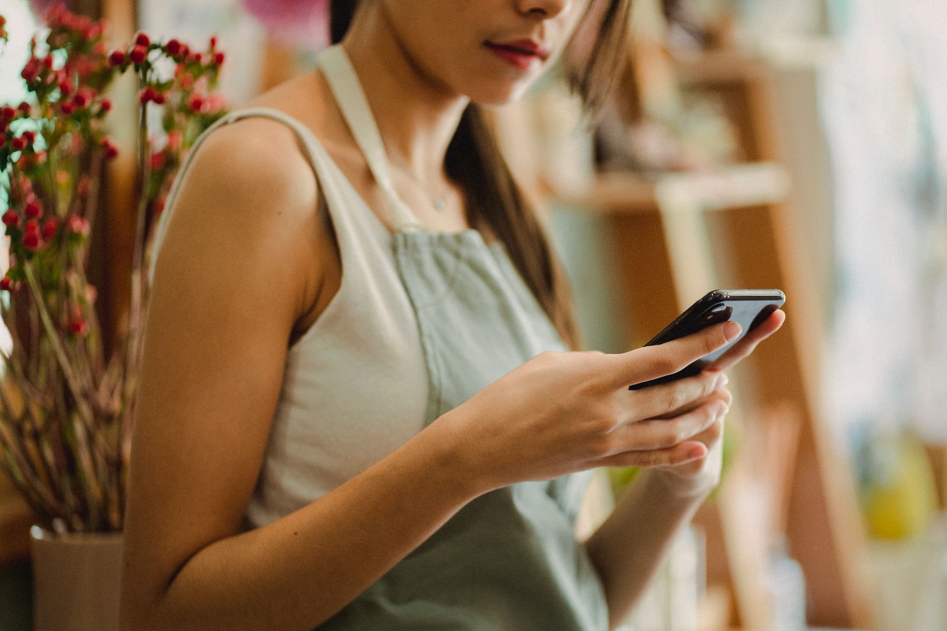 A service business owner replies promptly to a new enquiry on a smartphone while a notebook of pending jobs sits open nearby.