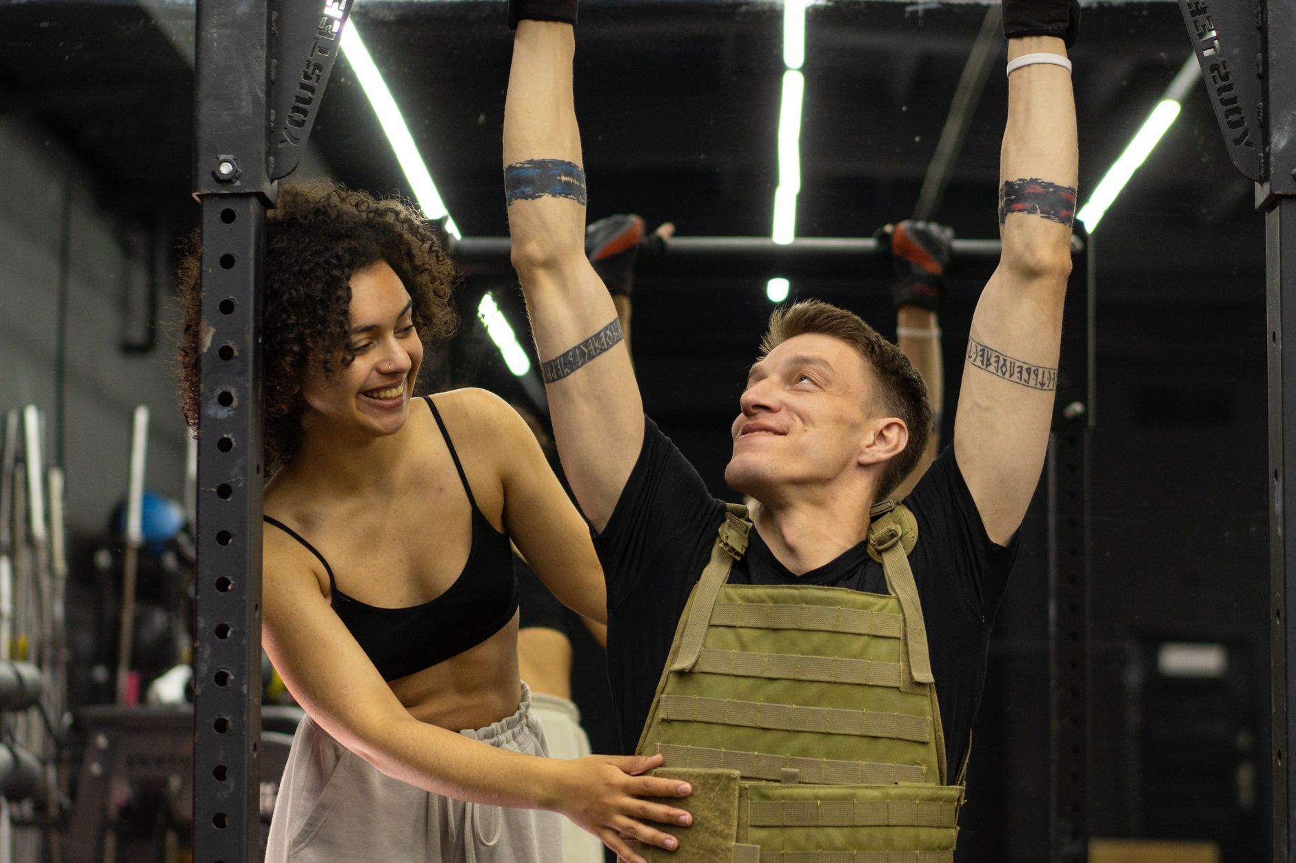 A delighted client checks their progress in the mirror after a session, reflecting a genuine, hard-earned training result.