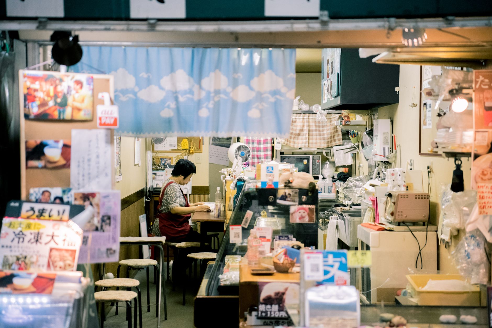 A shop owner checking weekly footfall and sales notes at the counter