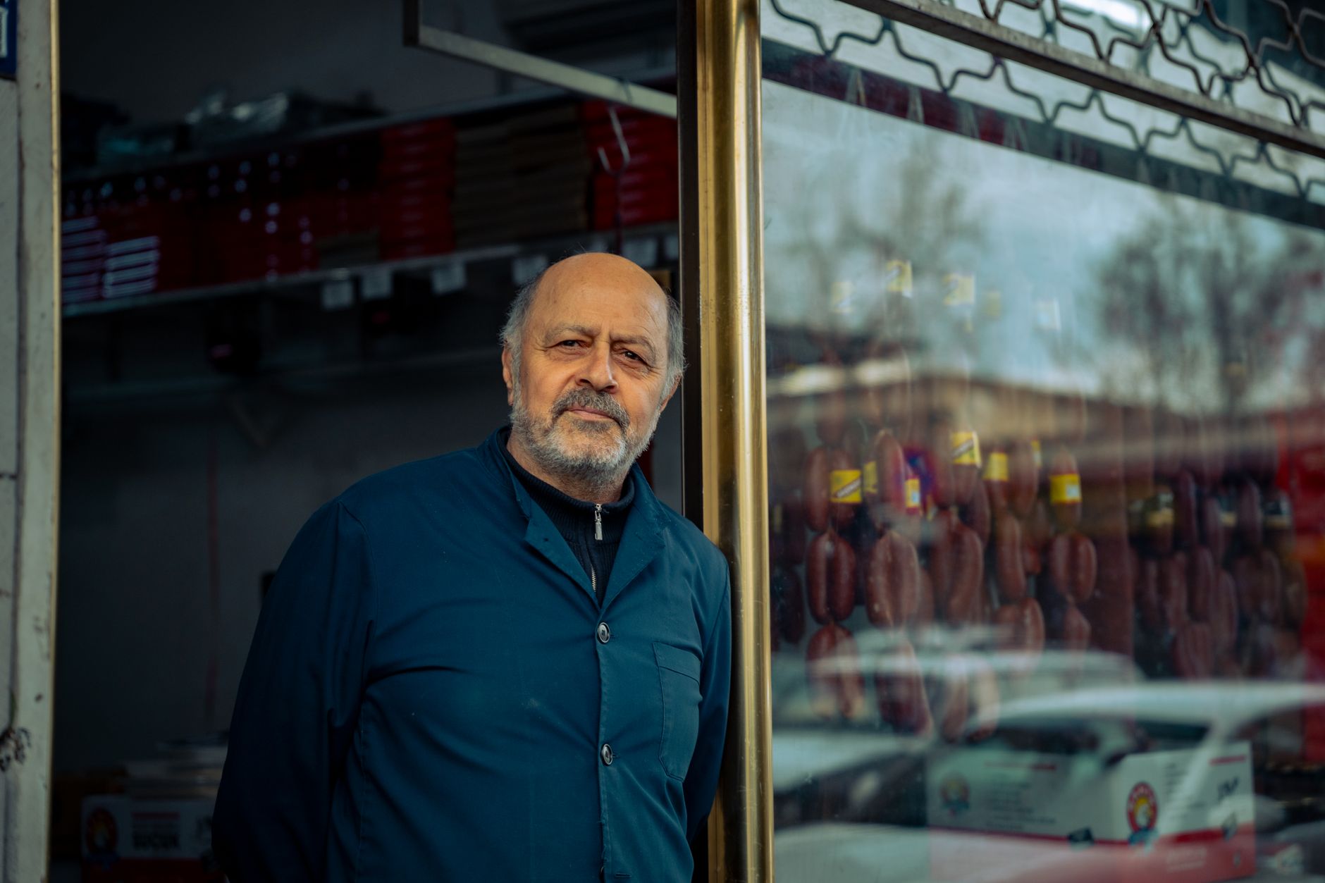 Two independent business owners shake hands outside a shopfront after agreeing to recommend each other to customers.