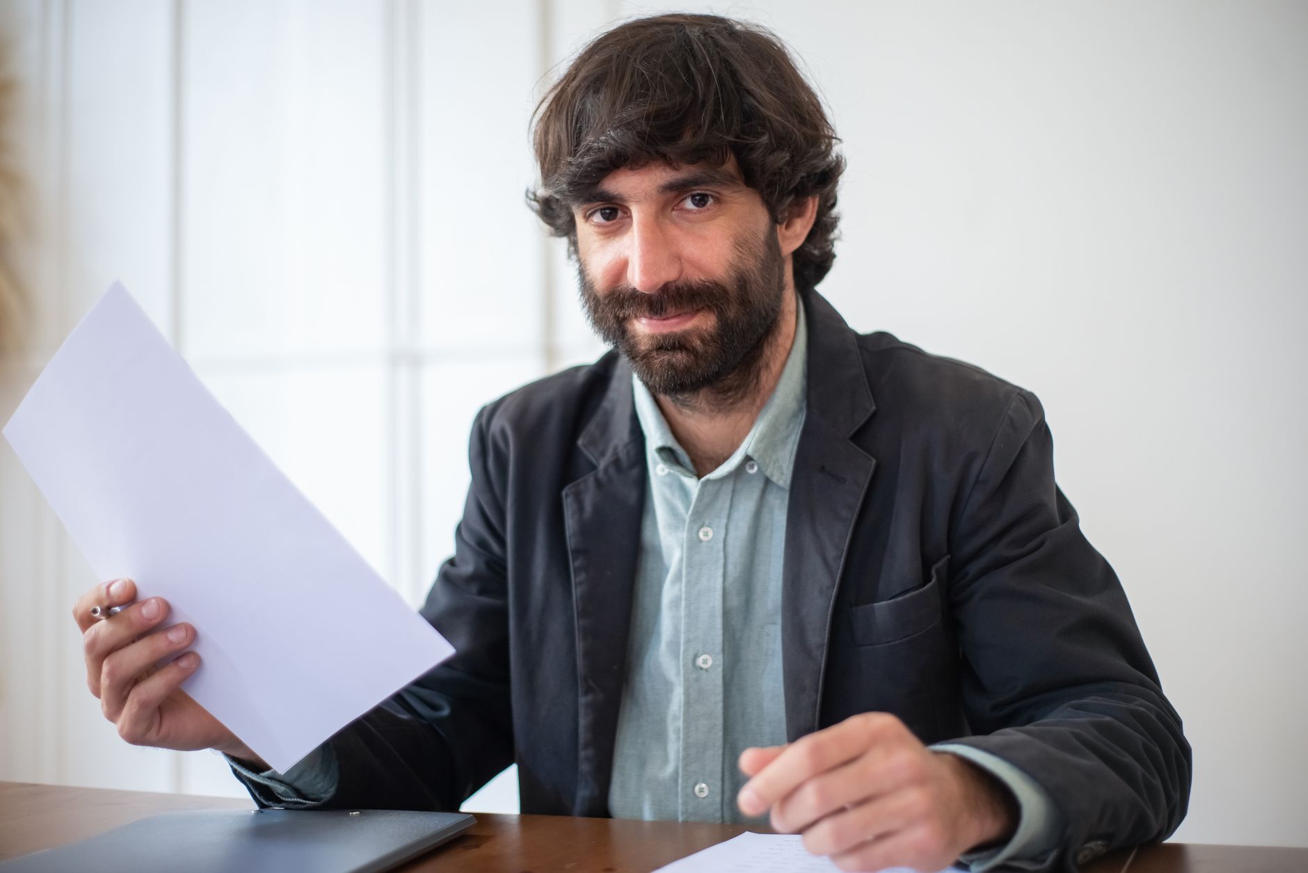 A confident consultant presents a proposal across a table to a client, leading with the result before the price.