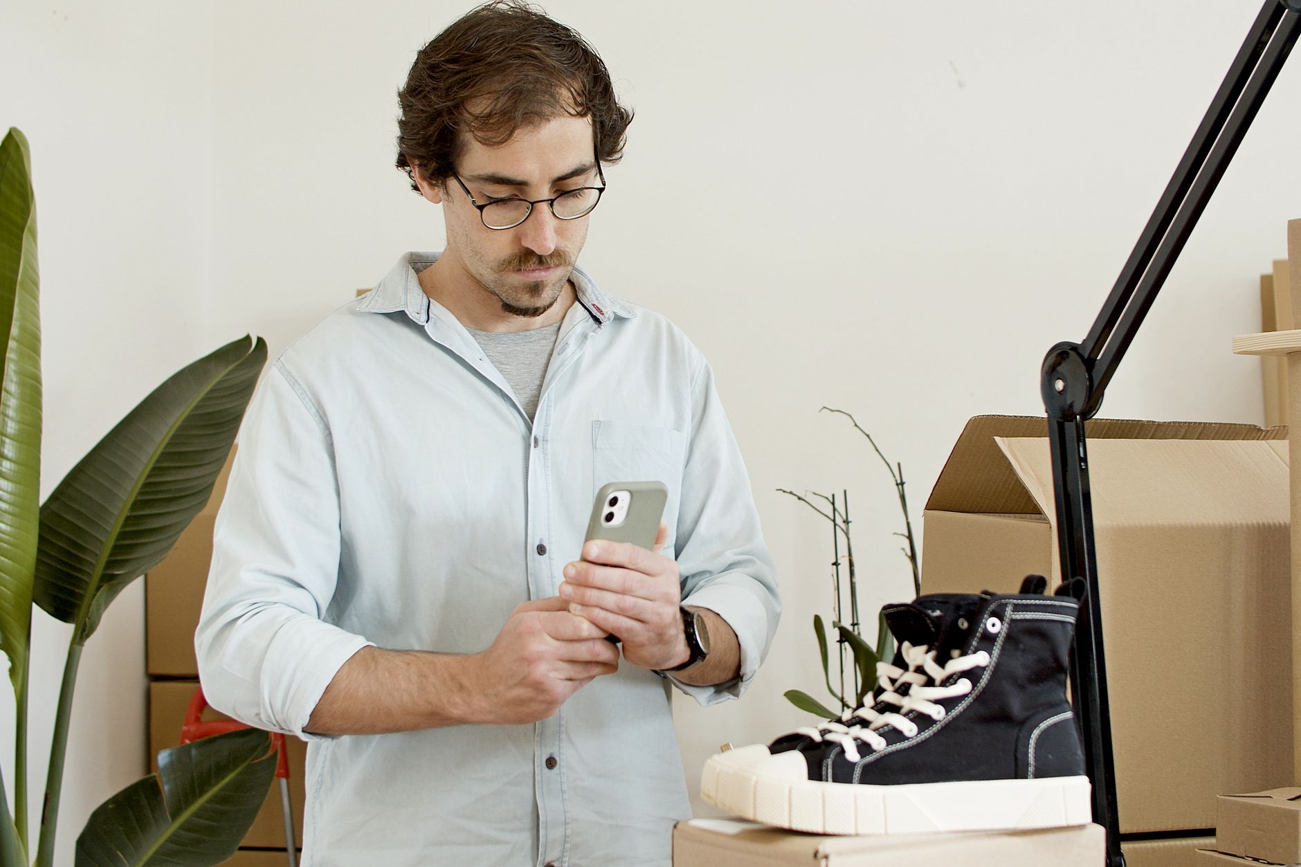 A small business owner photographs a finished piece of work on a phone to post on a single chosen channel.