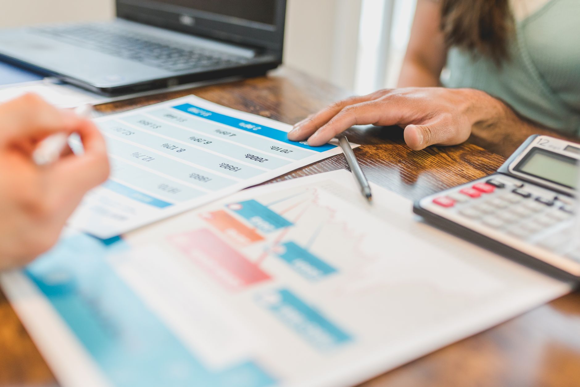 A business owner reviews launch figures with a calculator and a notebook, working out the revenue from her email list and conversion rate.
