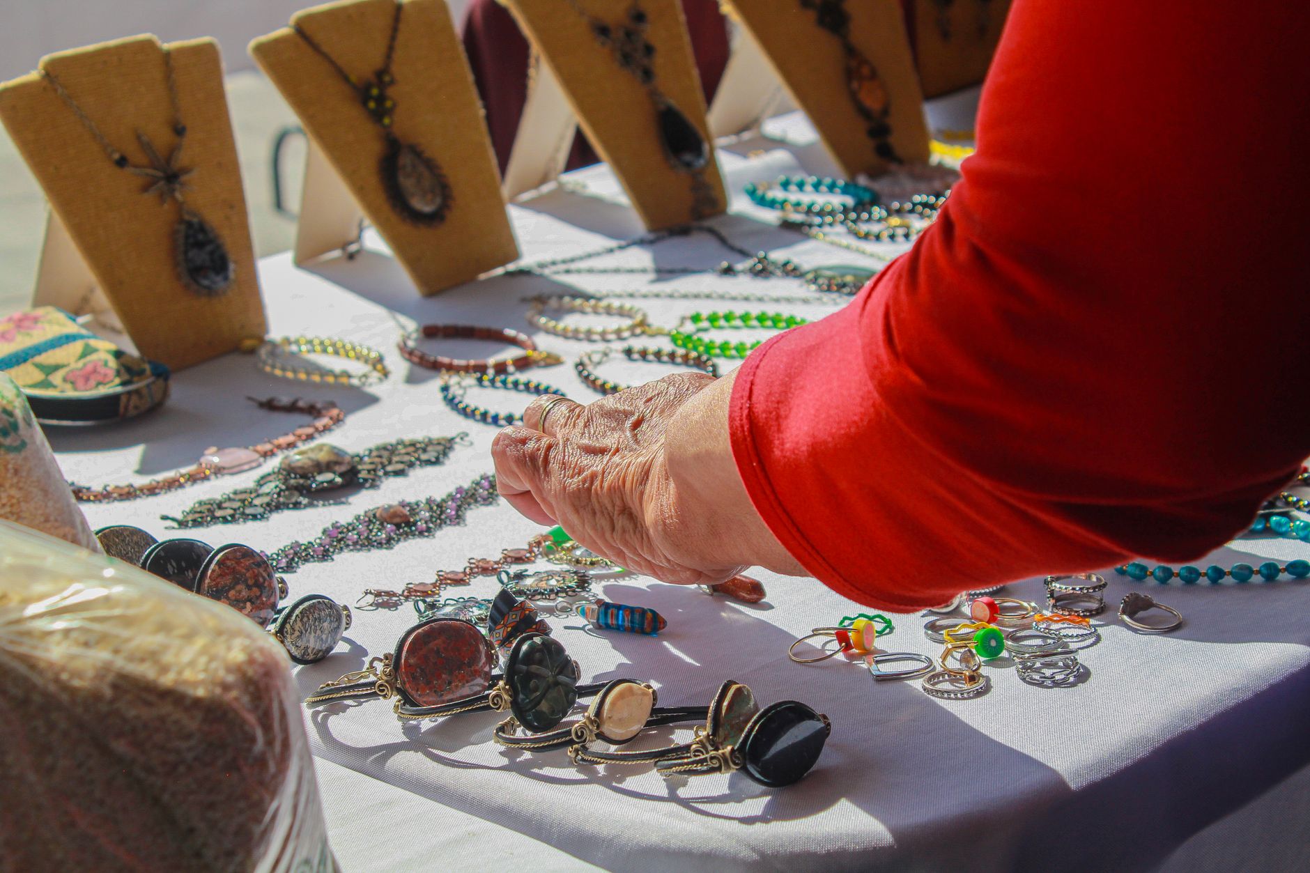 A jewellery maker arranging pieces on a stall display stand