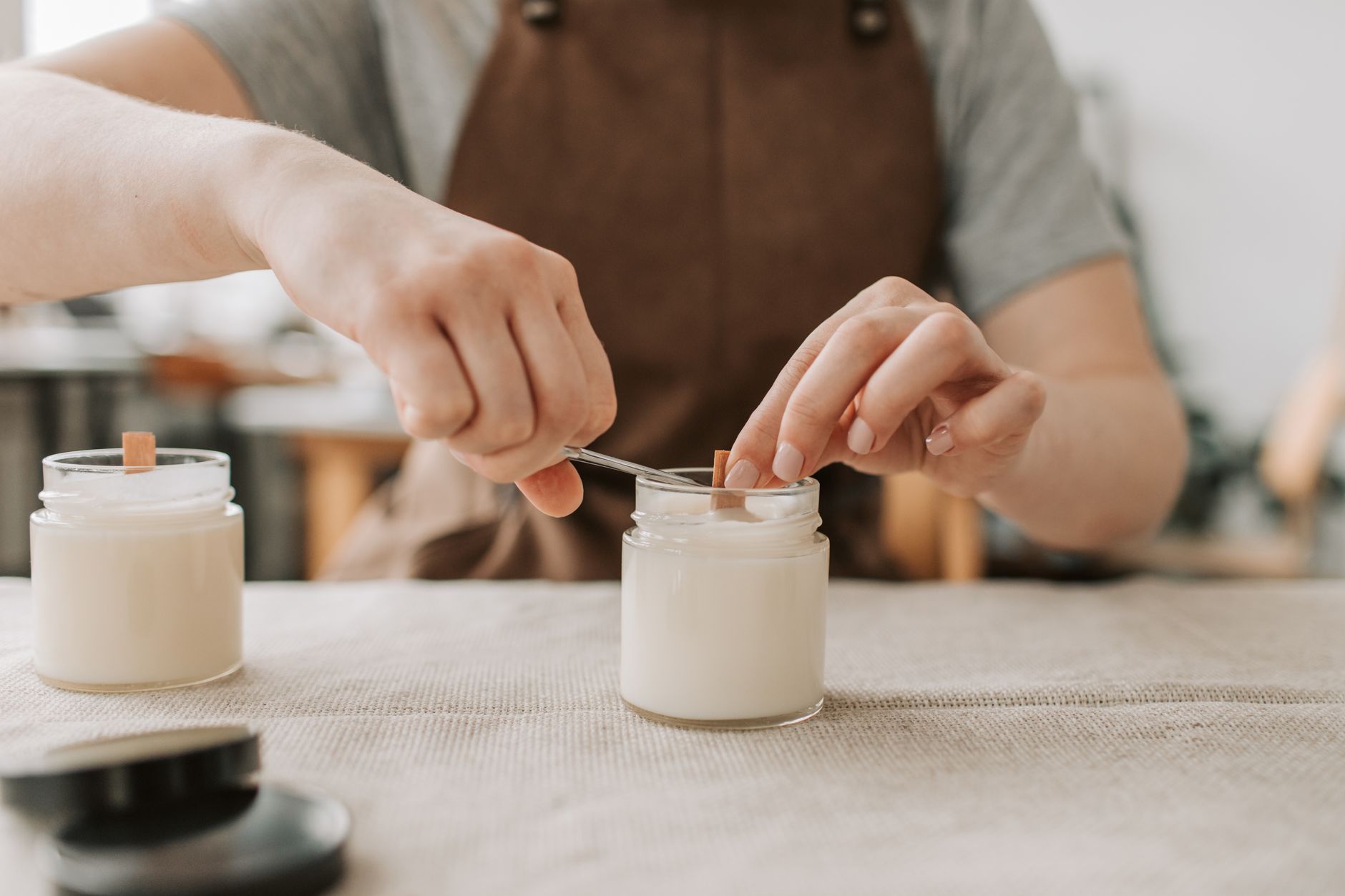 A candle maker labelling handmade candles with prices