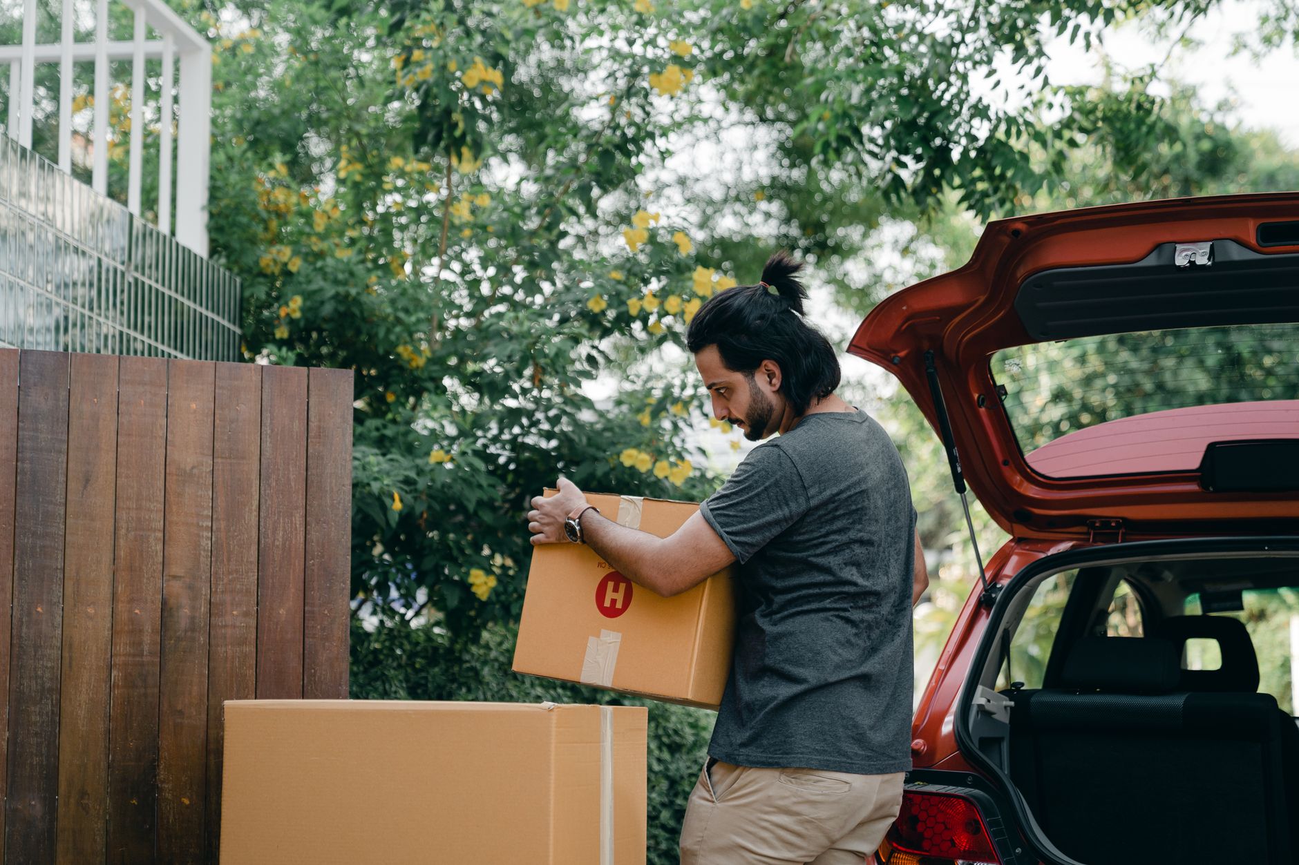 A maker loading boxes of stock into their car before a craft fair