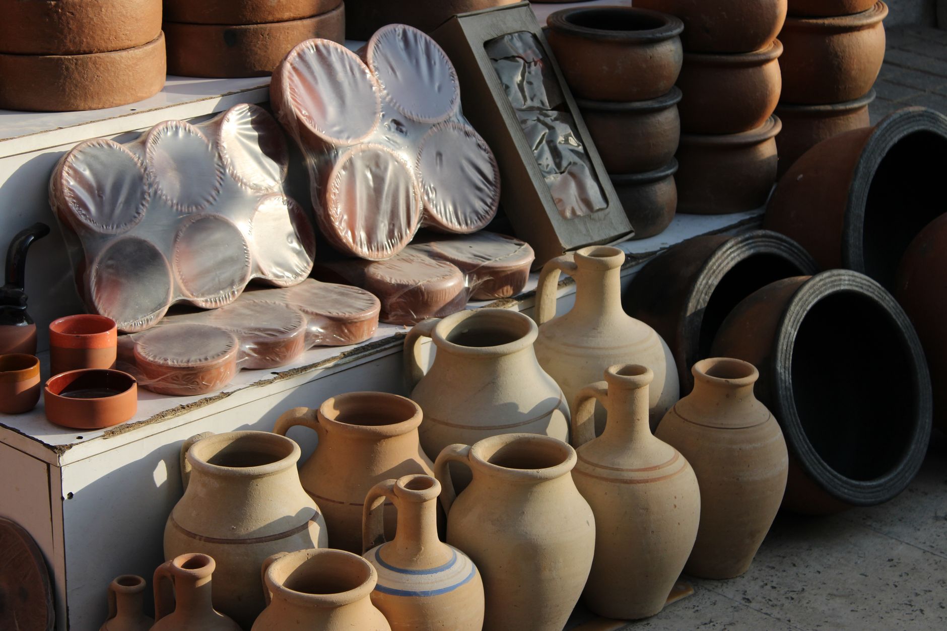 A maker arranging handmade pottery on their craft fair stall