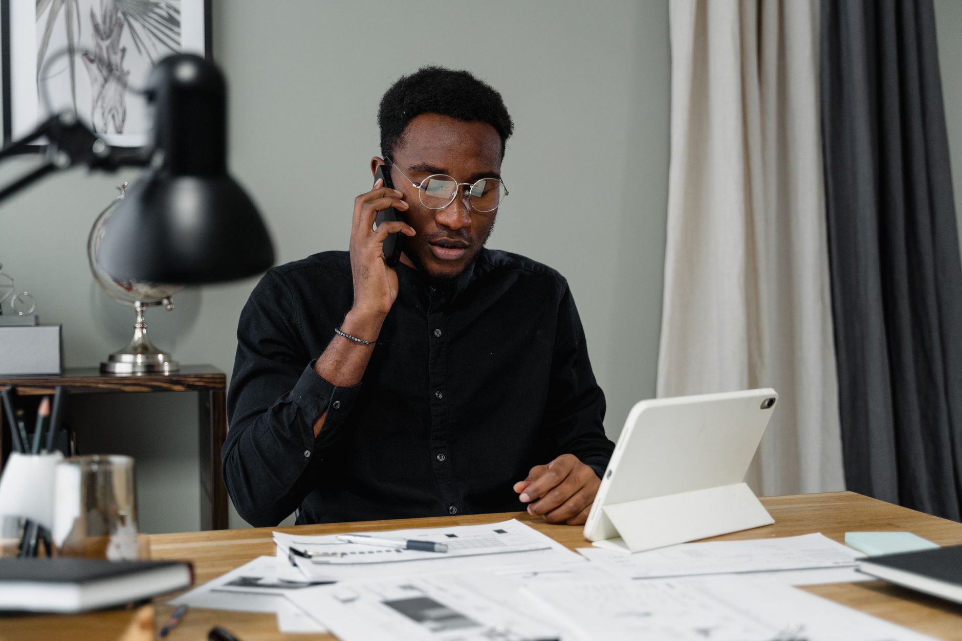 A person making a phone call at a desk at home to win their first customers