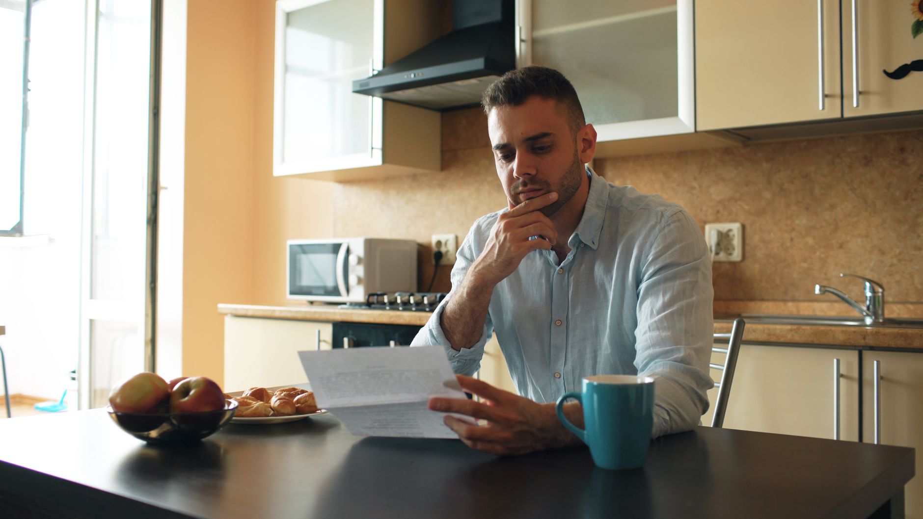 A person sitting at a table with a hand on their chin, weighing up the mistakes that sink a no budget business