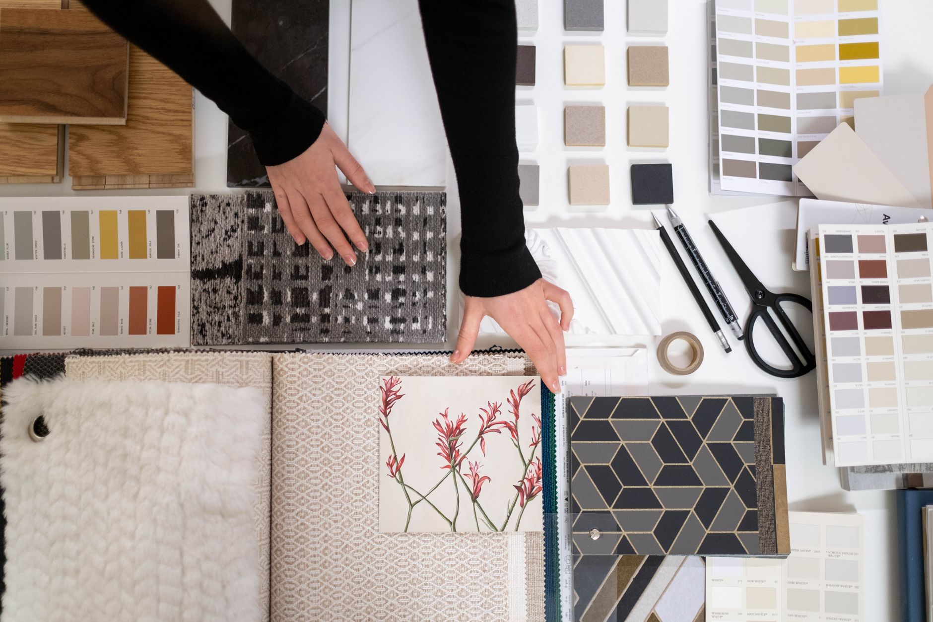 A person arranging fabric swatches and colours on a mood board to define a clothing brand