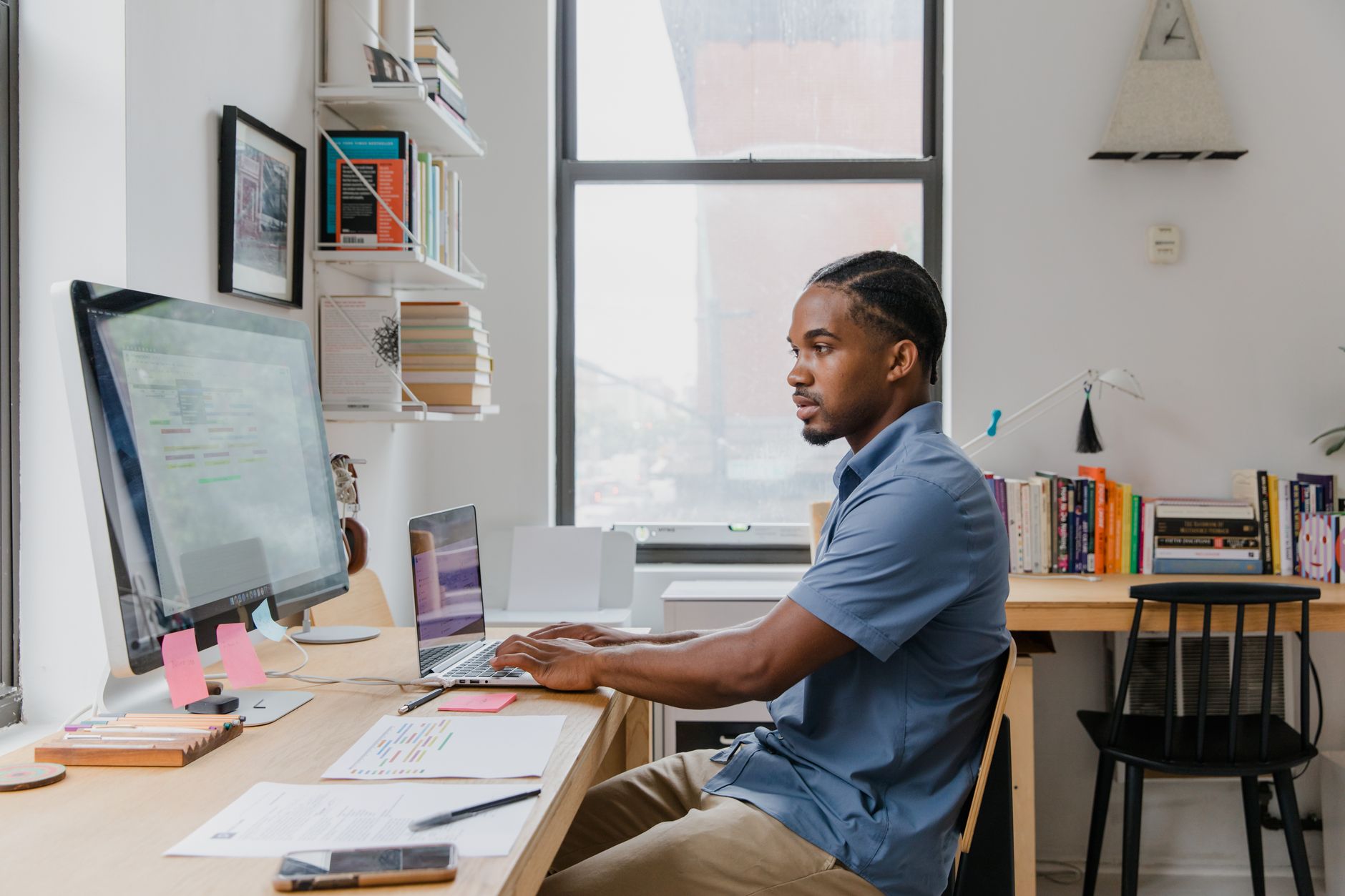 A small business owner sitting at a desk working on a laptop in a home office