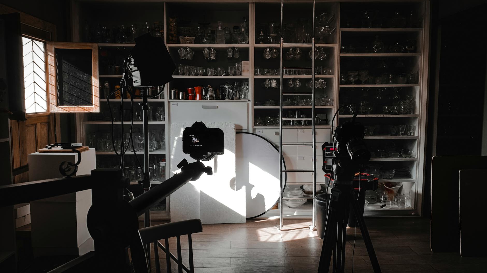 Interior view of a photography studio with cameras, lights, and equipment setup for a shoot.